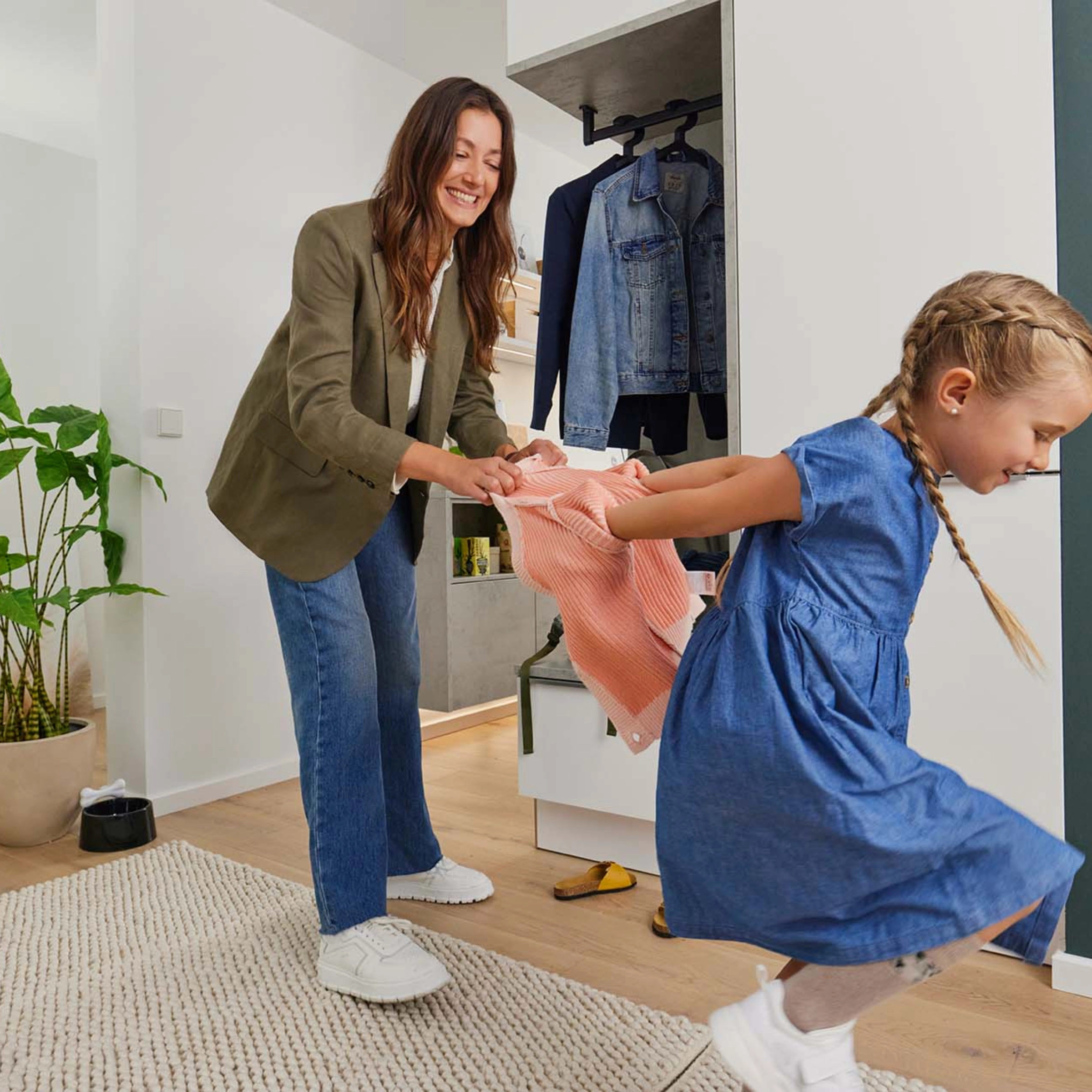 Une femme aide un enfant à jouer dans un espace moderne avec des meubles Nolte Living.