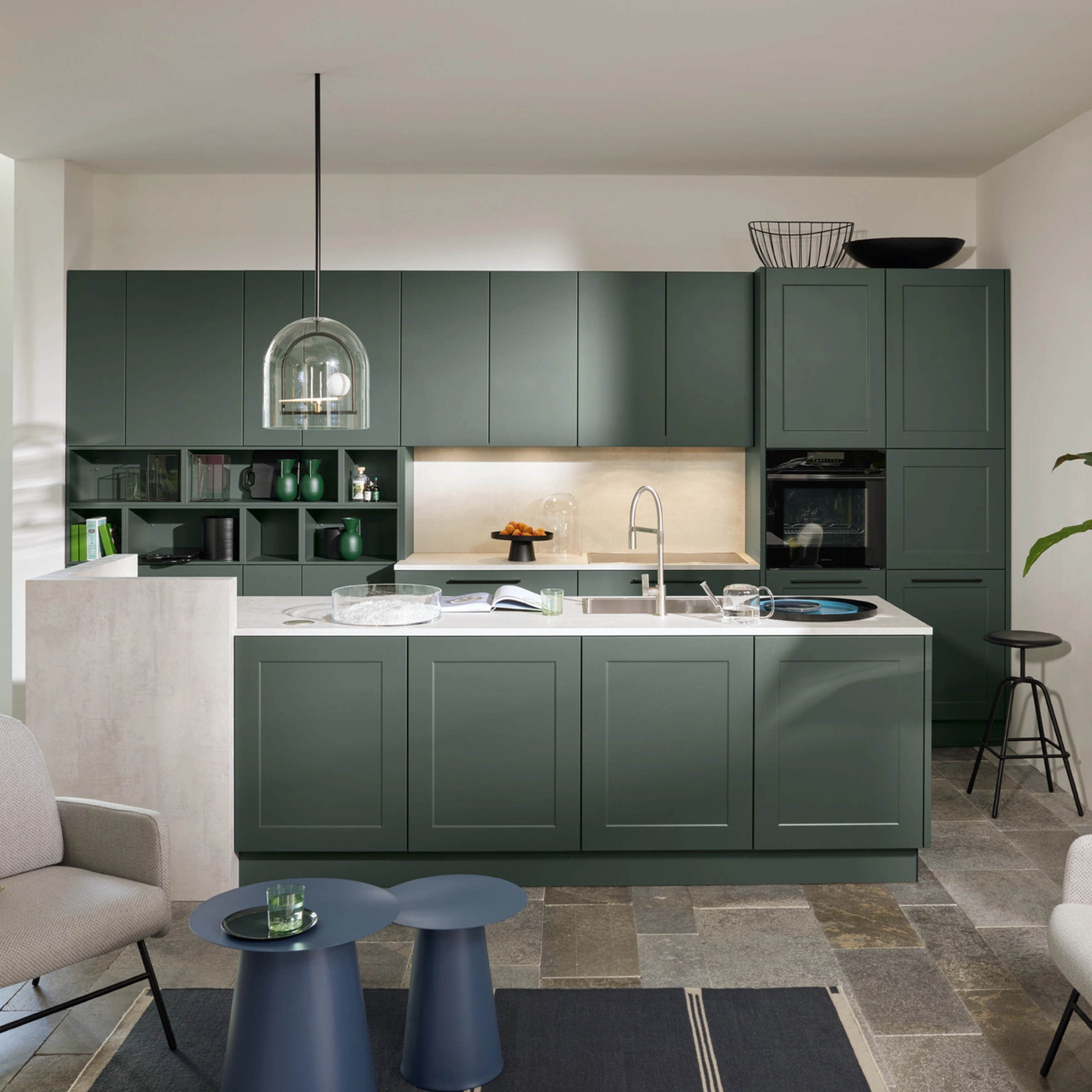 Cuisine moderne avec armoires vertes et îlot dans un espace ouvert. Nolte Kitchen.