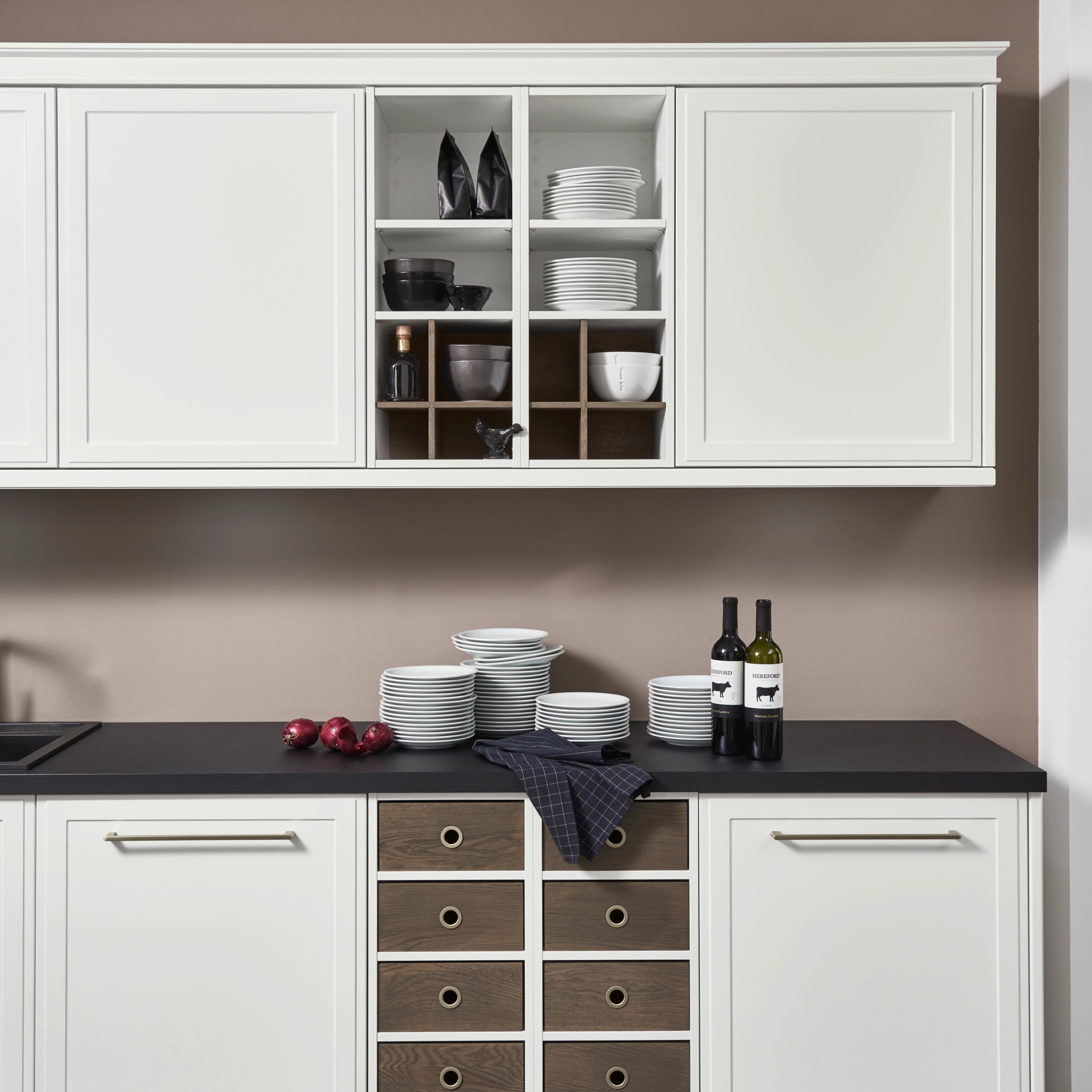Cuisine moderne avec armoires blanches et plan de travail sombre, présentée par Nolte Kitchen.