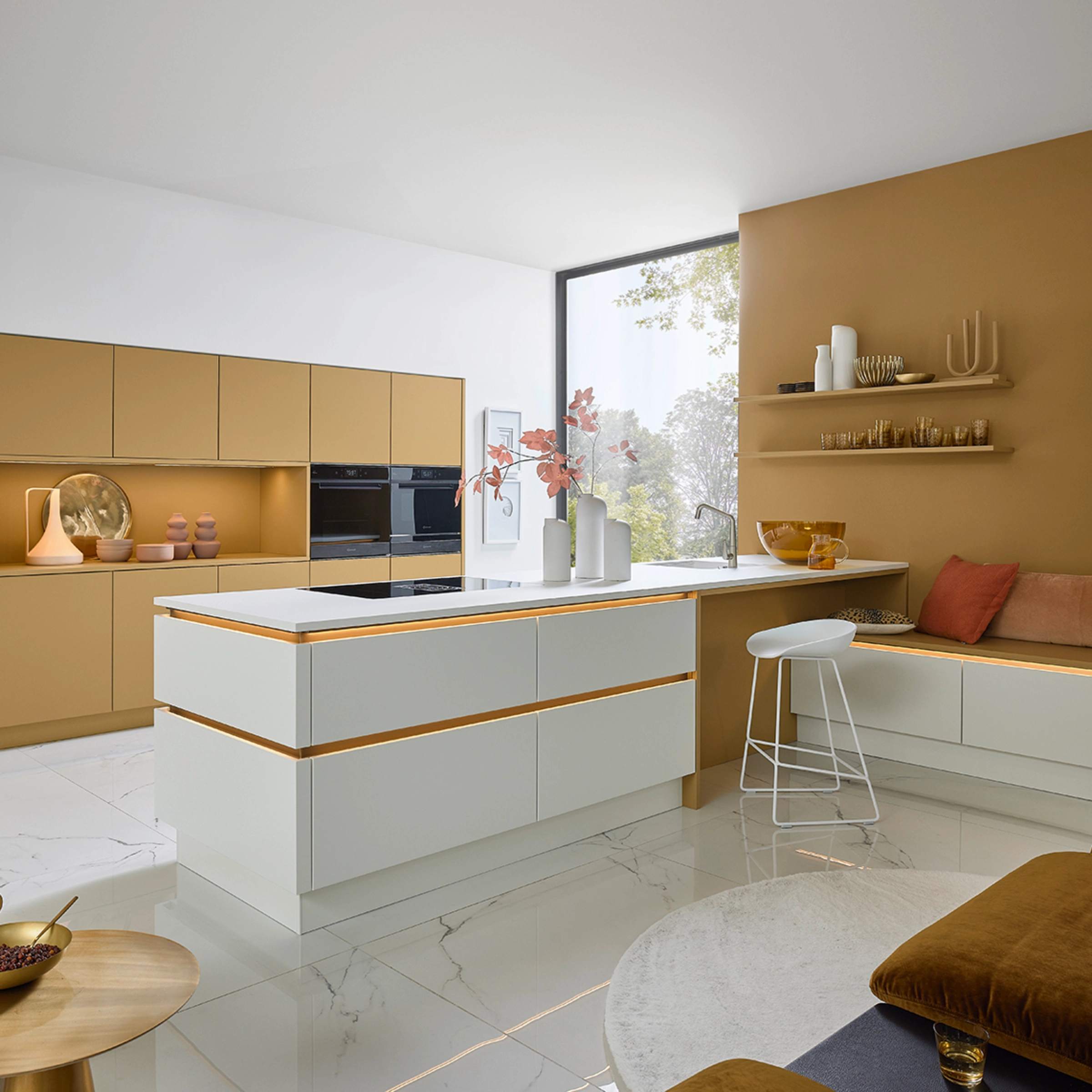 Une cuisine moderne avec des éléments blancs et dorés, équipée par Nolte Kitchen.