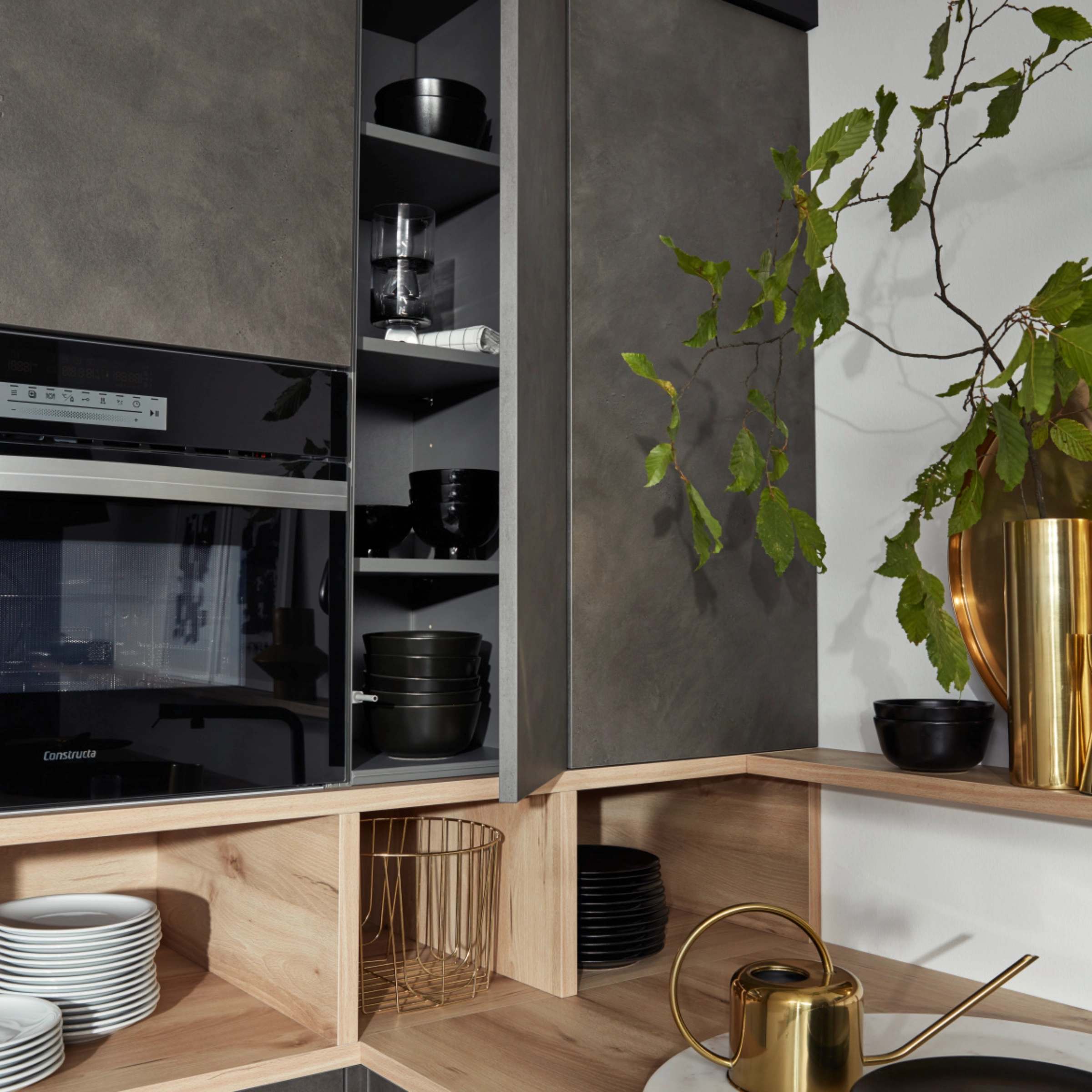 Cuisine moderne avec armoires grises et détails en bois, décorée de plantes. Nolte Kitchen.