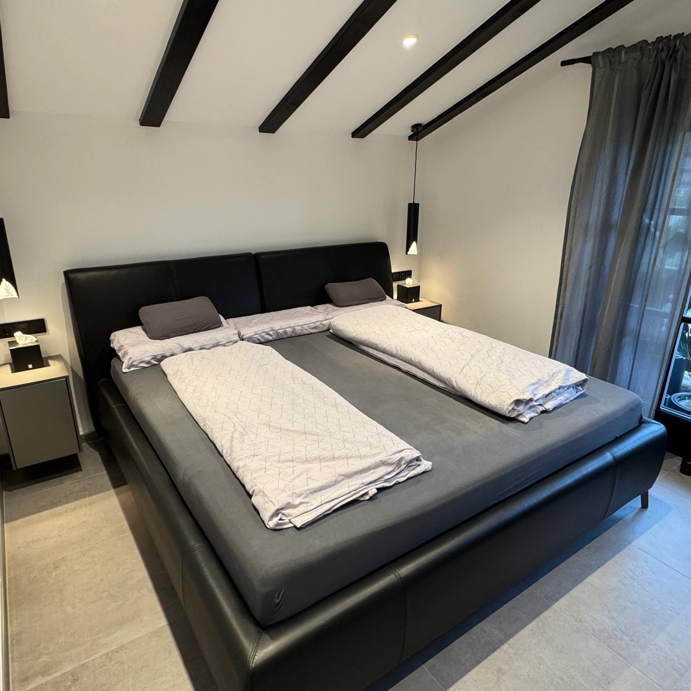 Camera da letto con un grande letto e design moderno, Nolte Living.