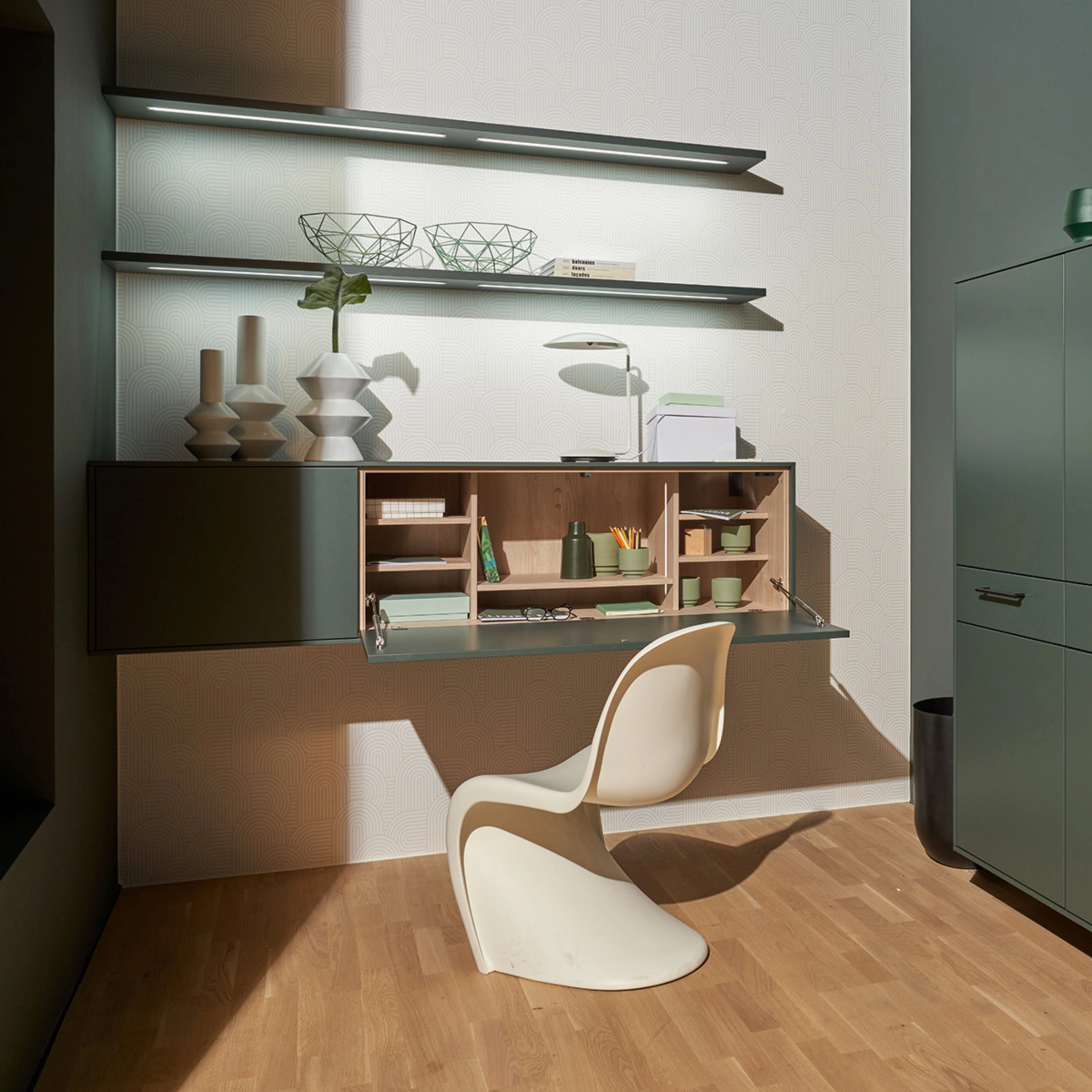 Un espace de travail élégant avec armoire verte et étagère de Nolte Living.