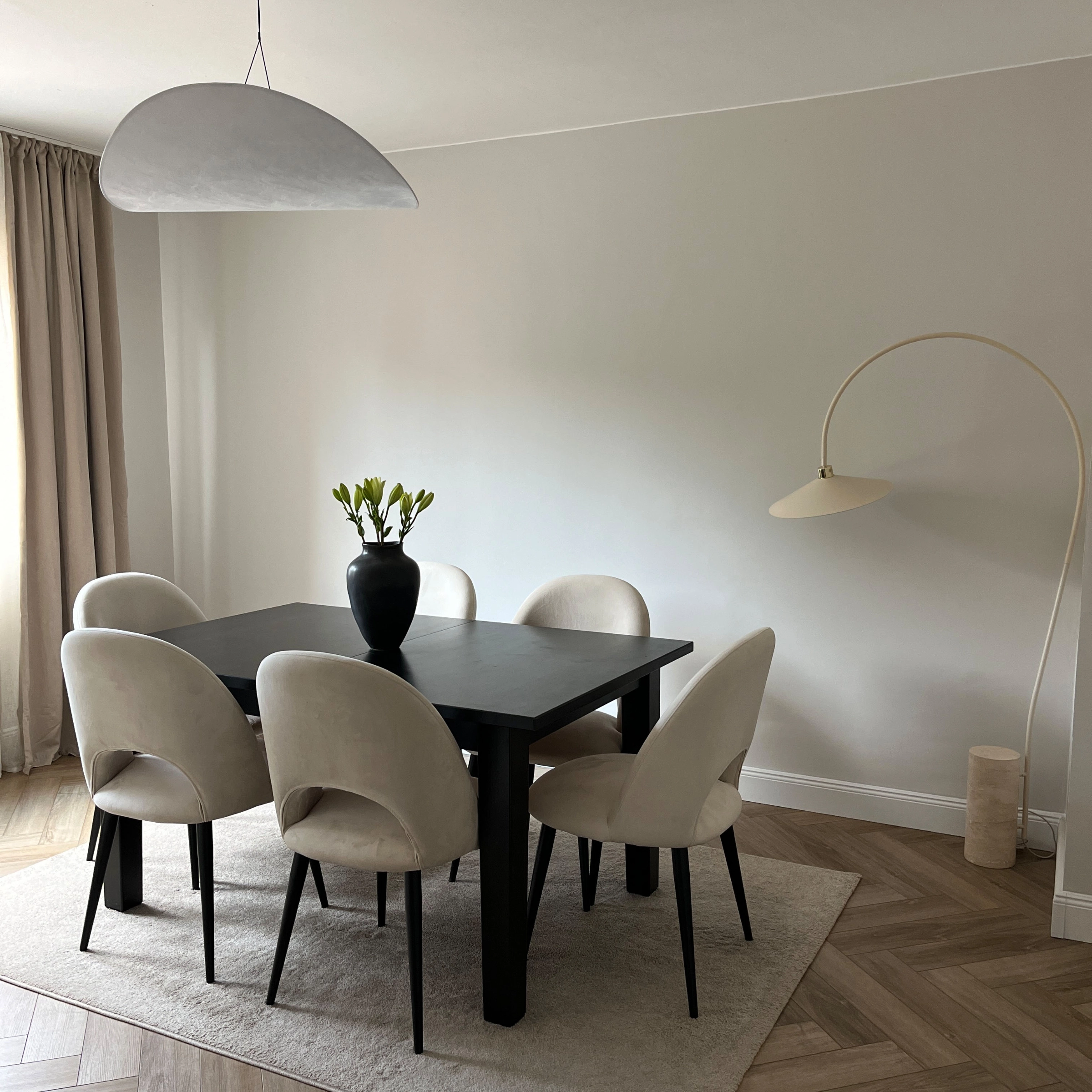 Une salle à manger élégante avec table sombre et chaises claires, assortie à Nolte Living.