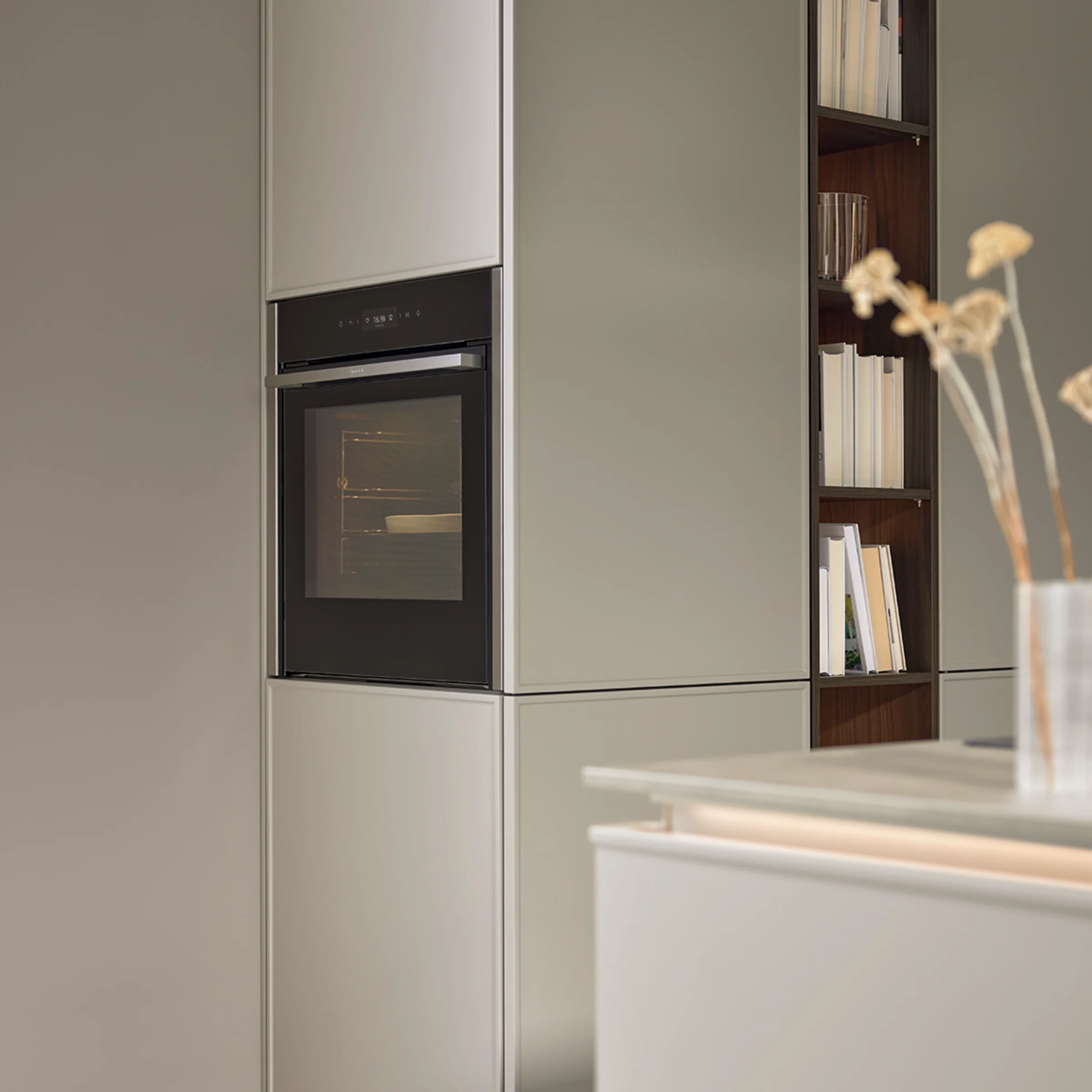 In der modernen Küche sind graue Schränke mit einem integrierten Backofen zu sehen. Nolte Küchen.