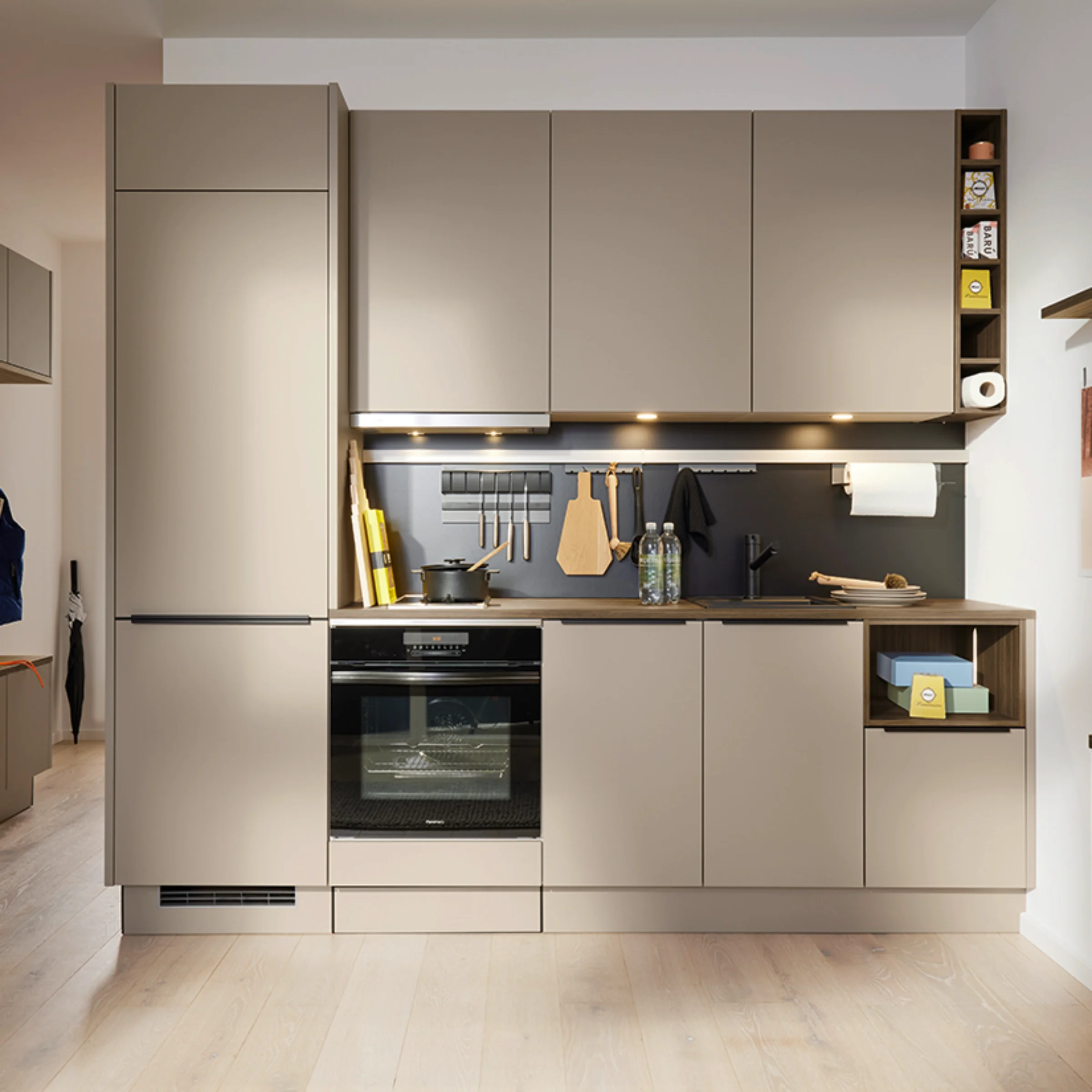 Une cuisine moderne avec des placards beiges et des appareils intégrés; Nolte Kitchen.