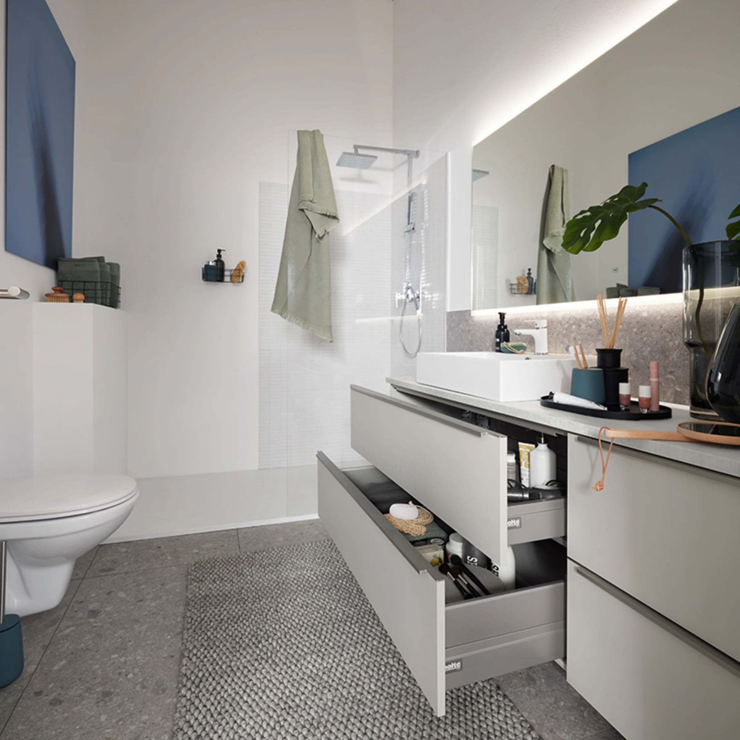 Une salle de bain moderne avec grand miroir et tiroir ouvert de Nolte SPA.