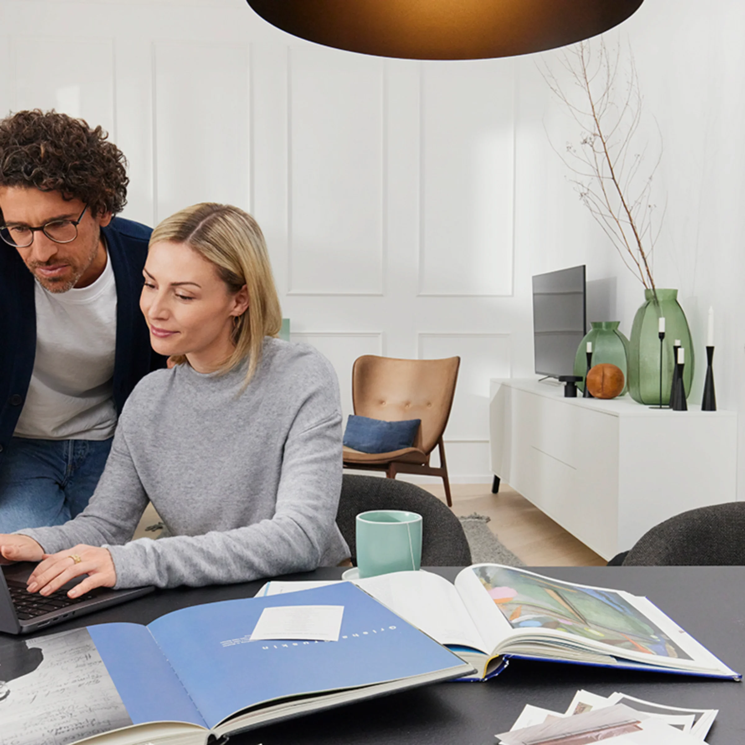 Ein Paar arbeitet an einem Laptop in einem modernen Wohnzimmer mit Nolte Living.
