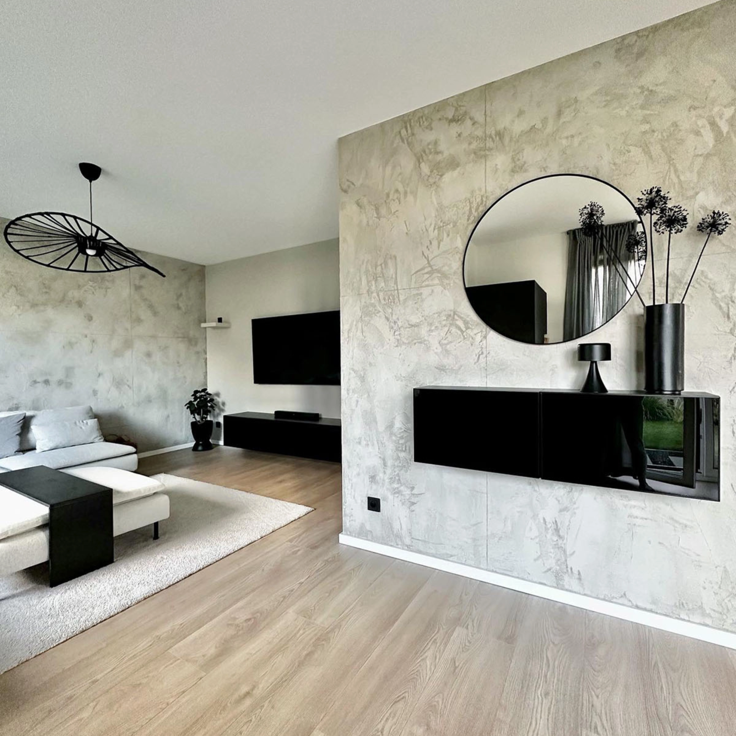 Un salon moderne avec déco noire, canapé et télé, conçu par Nolte Living.