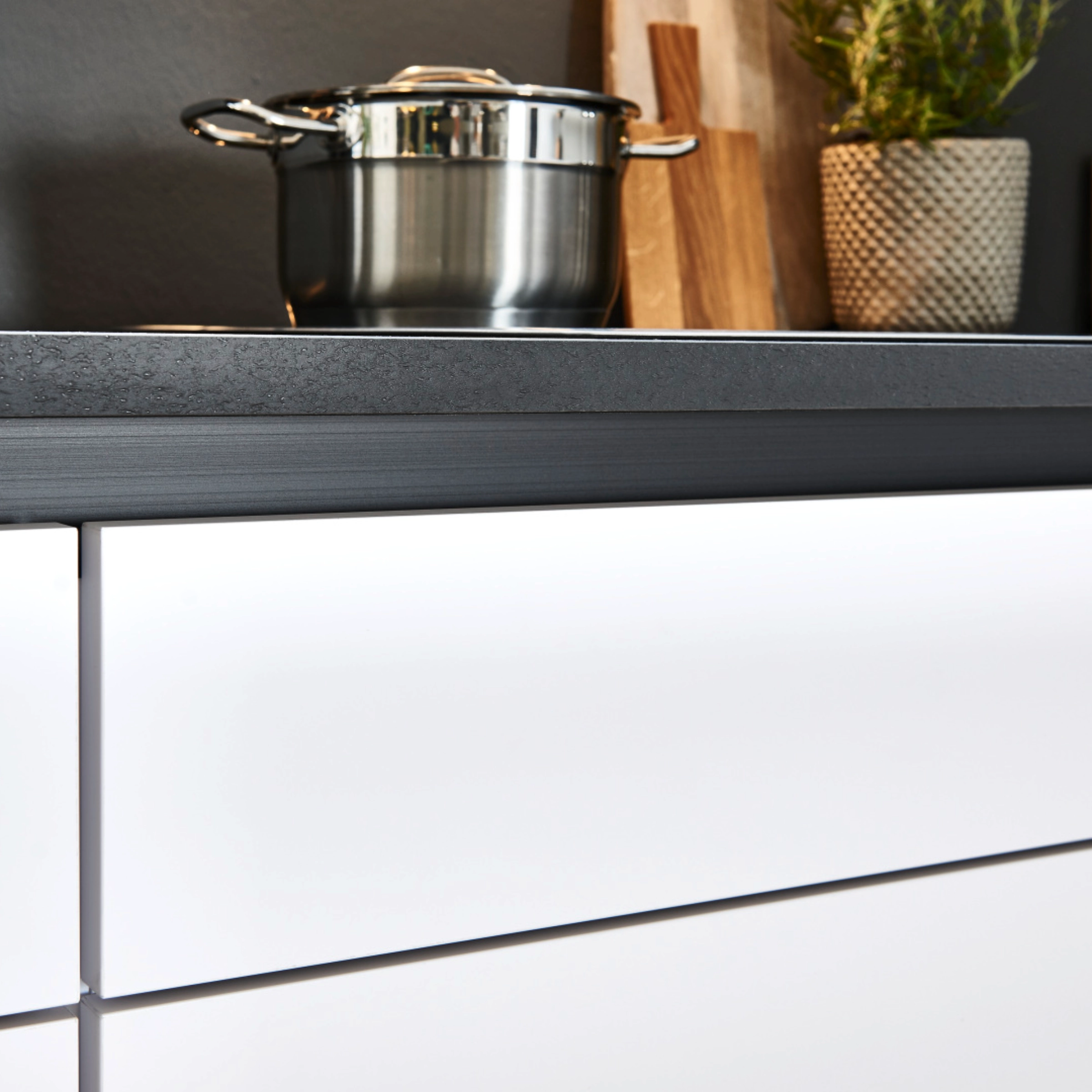 Cuisine moderne avec casserole et planche à découper sur le plan de travail, intégrée dans Nolte Kitchen.
