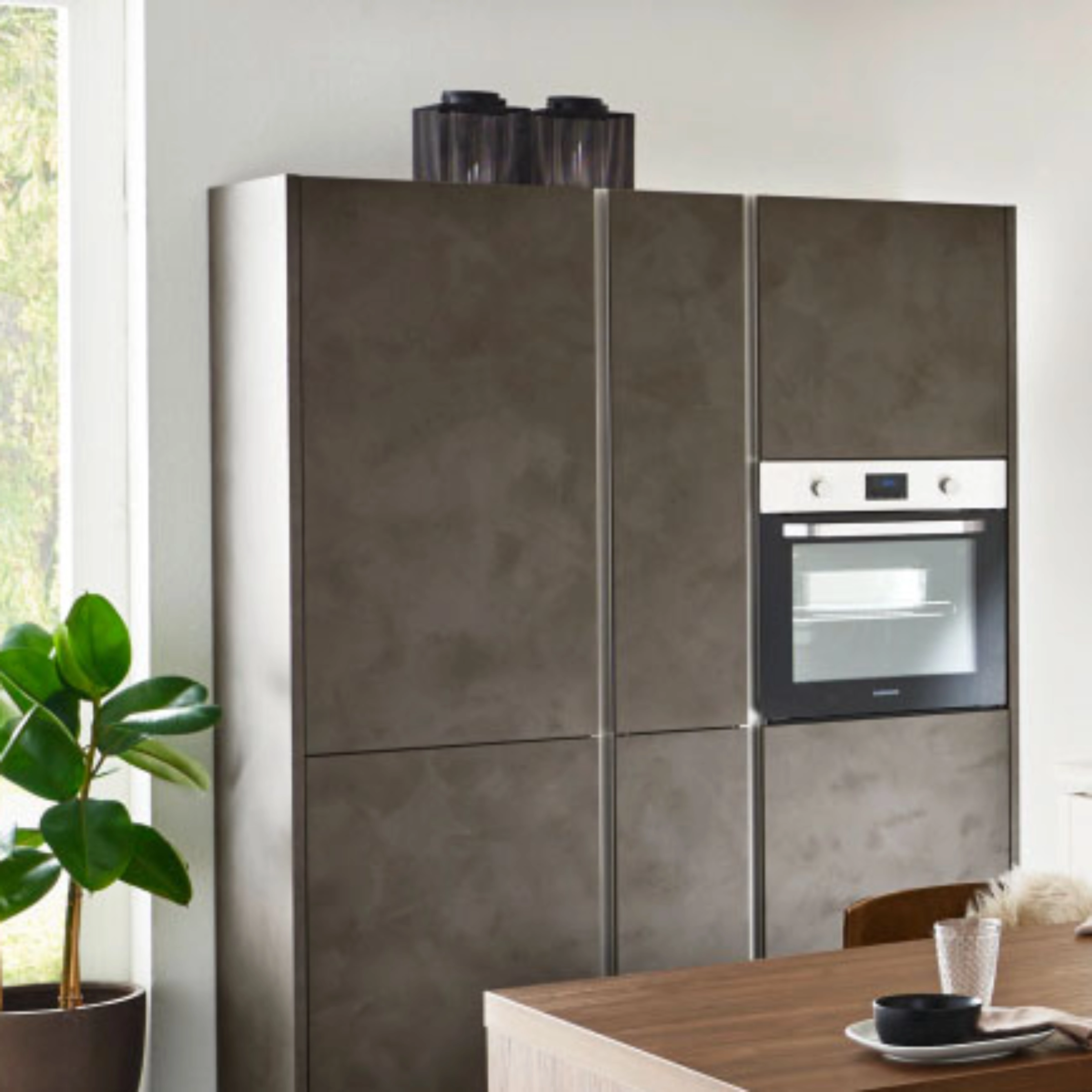 Een moderne keuken met grijze kasten en een ingebouwde oven van Nolte Kitchen.