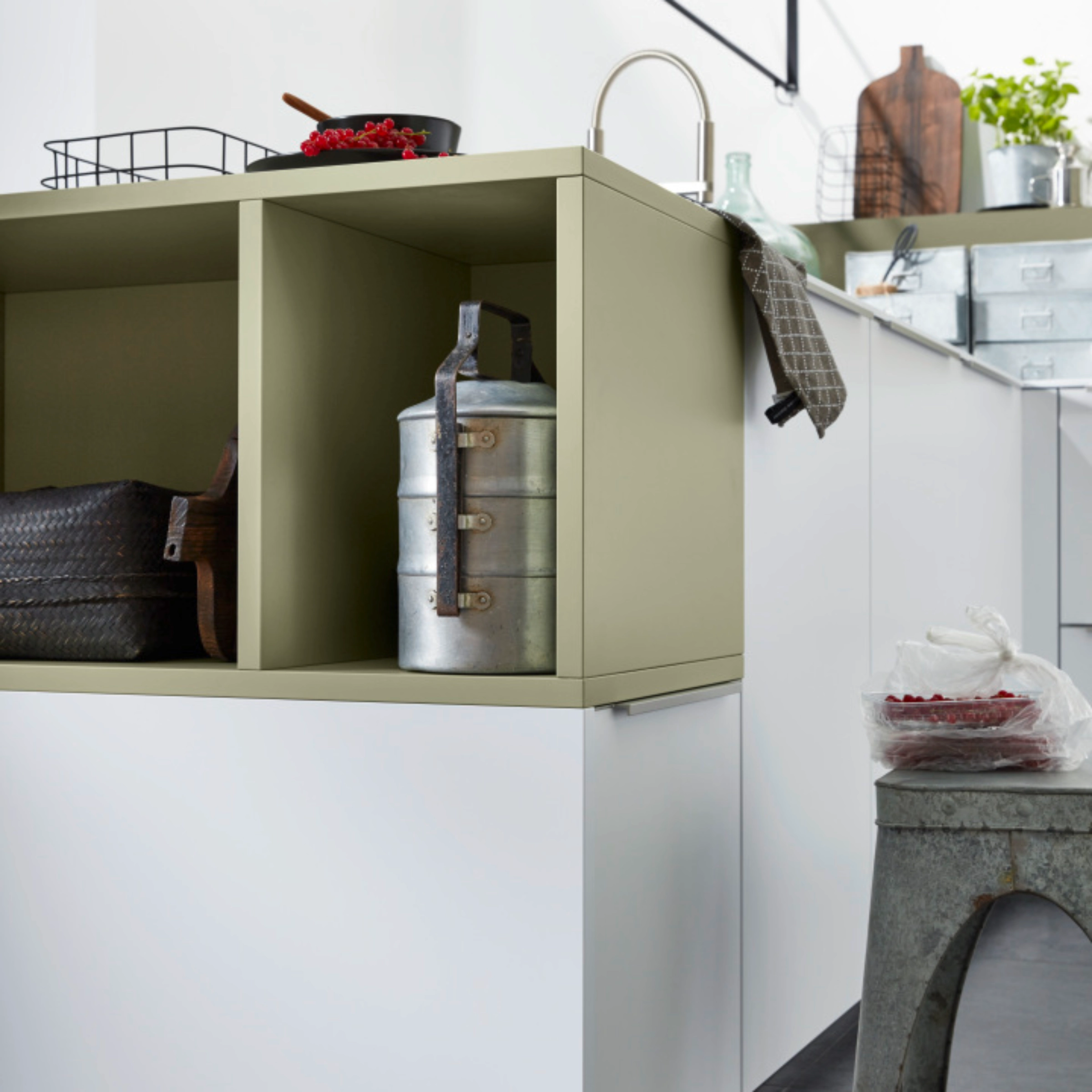 Une cuisine moderne avec des éléments blancs et vert olive de Nolte Kitchen.