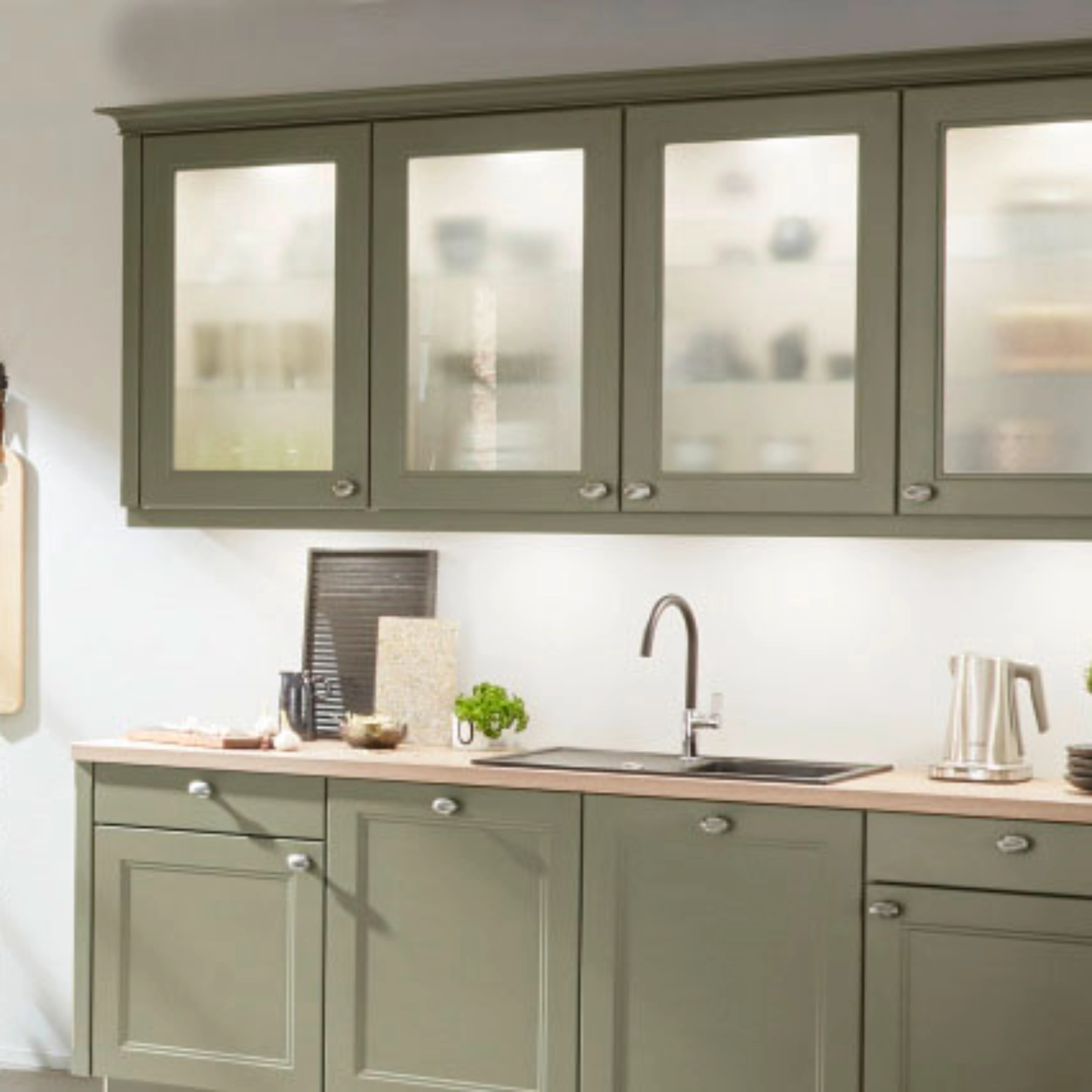 Una cucina moderna con armadi verdi e decorazioni. Nolte Kitchen.