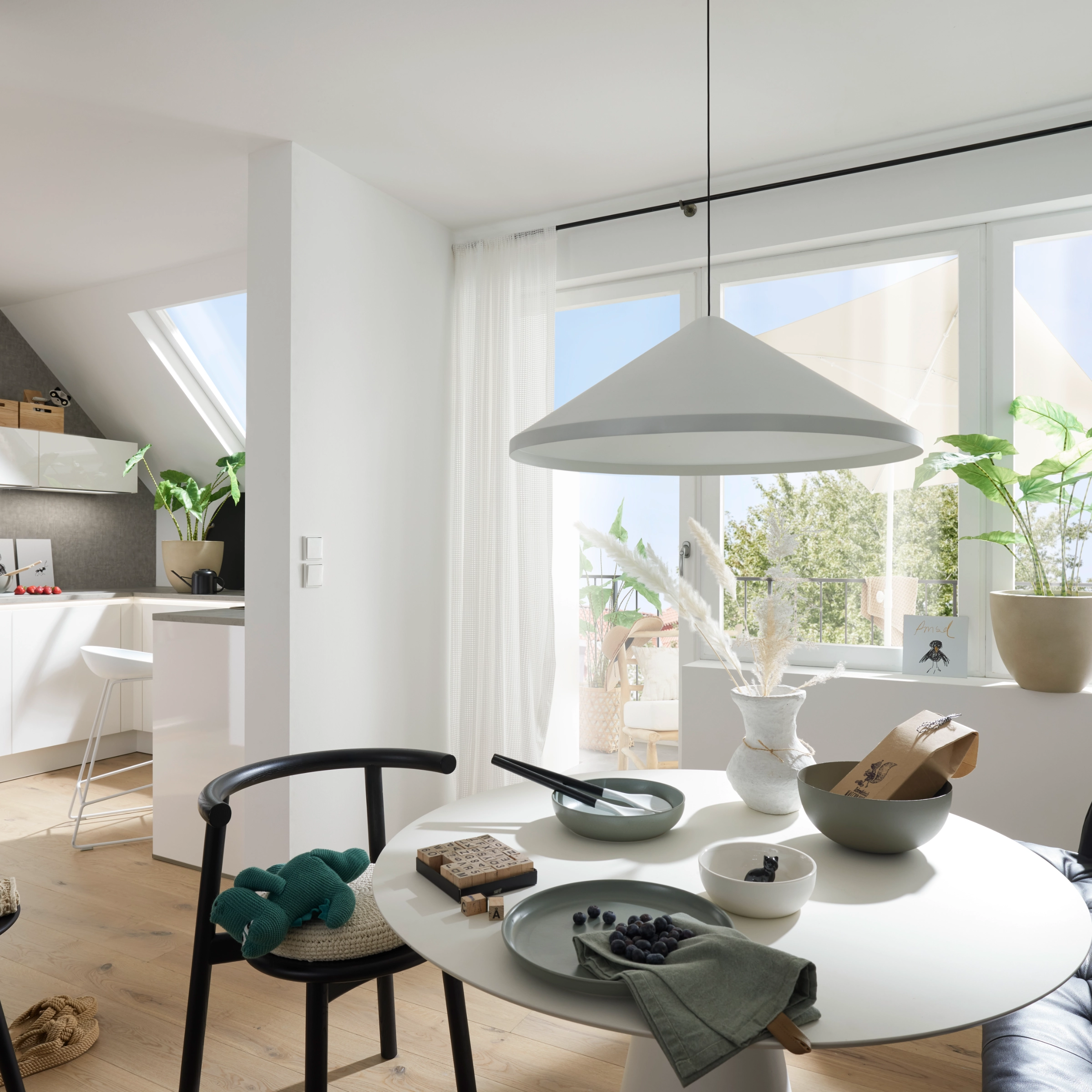 Ein moderner Wohnbereich mit Essplatz und Küche, mit Design von Nolte Living.
