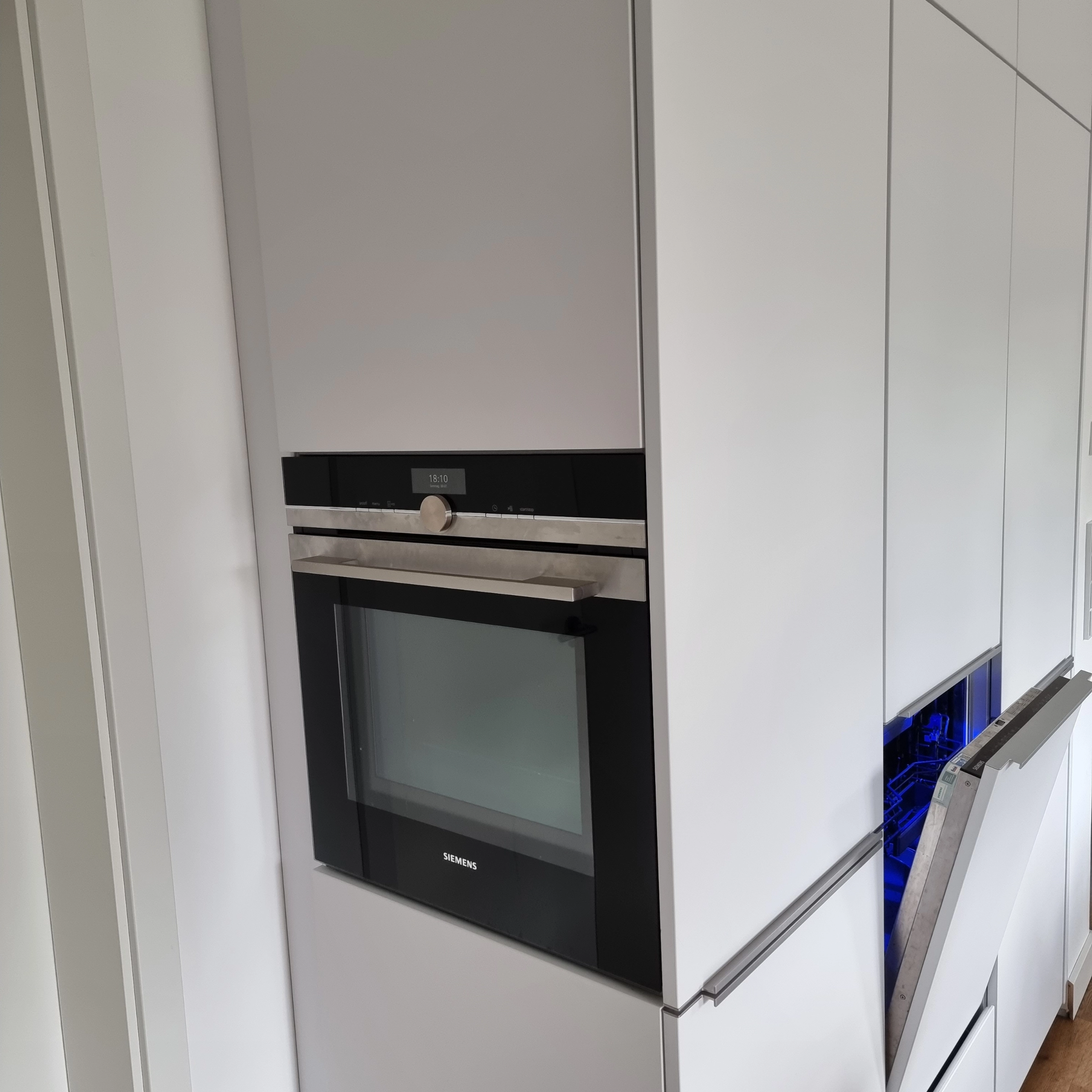 Een moderne inbouwkeuken met witte kasten en ingebouwde oven, van Nolte Kitchen.