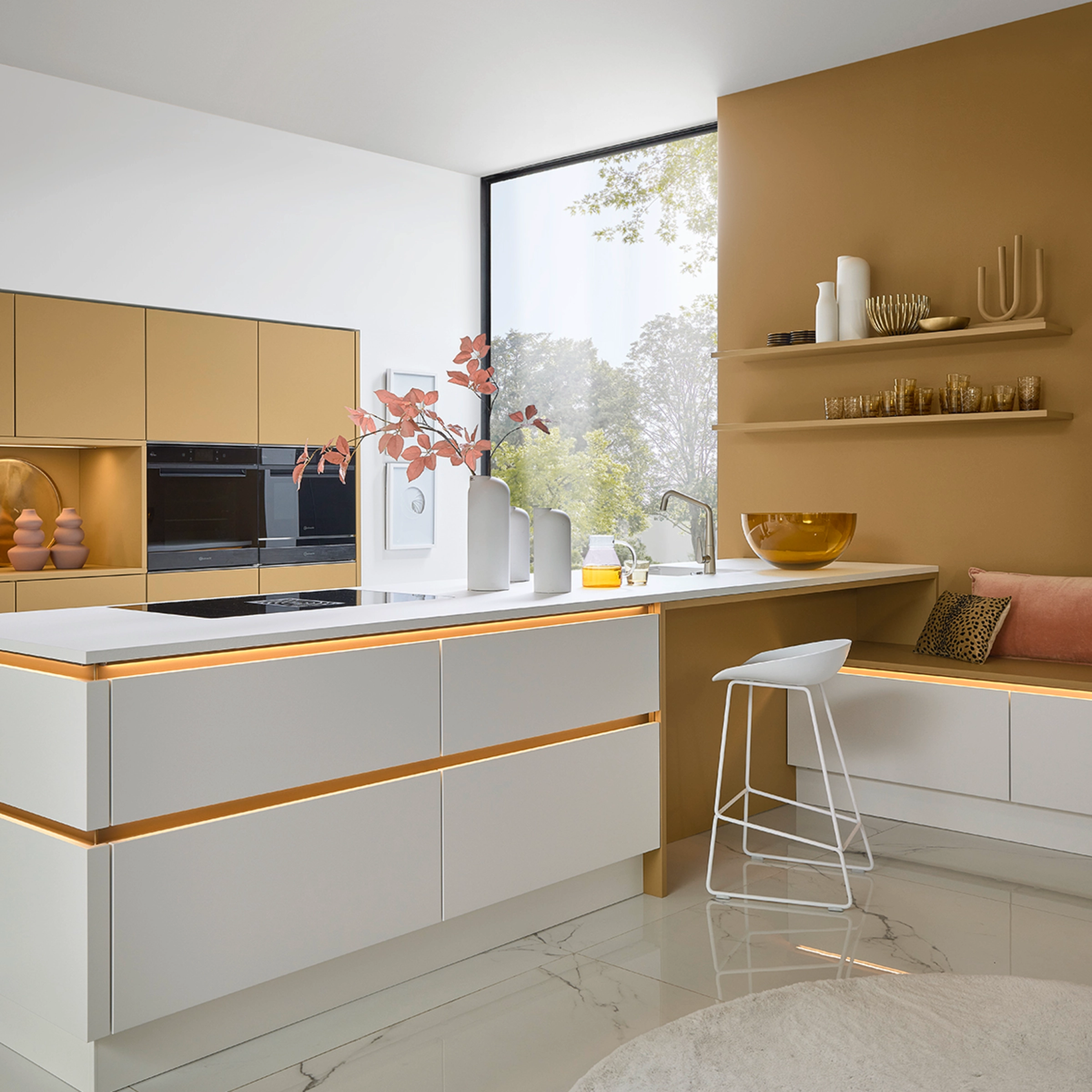 Cuisine moderne avec façades blanches et accents dorés, équipée par Nolte Kitchen.