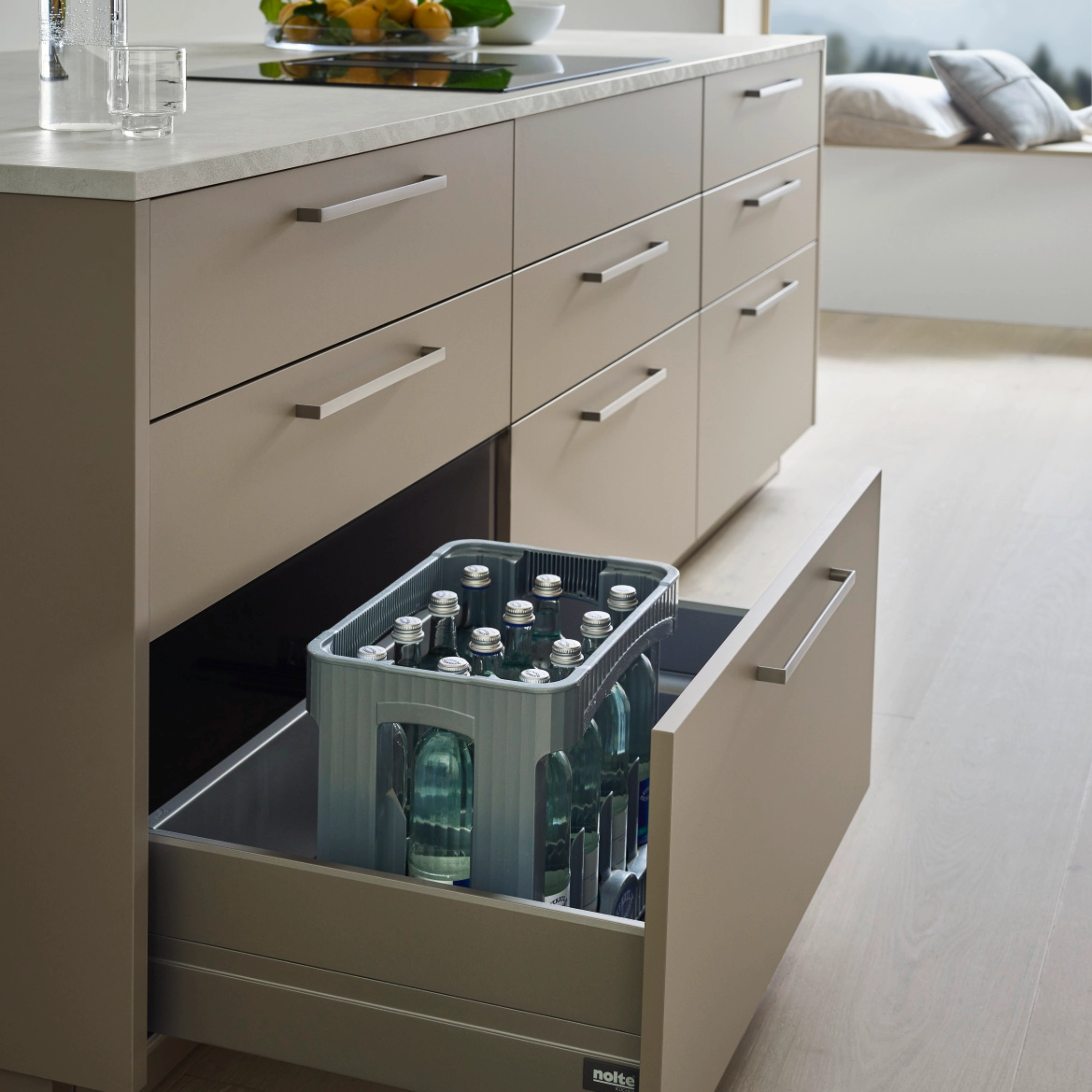 A modern kitchen with an open drawer containing bottles. Nolte Kitchen.