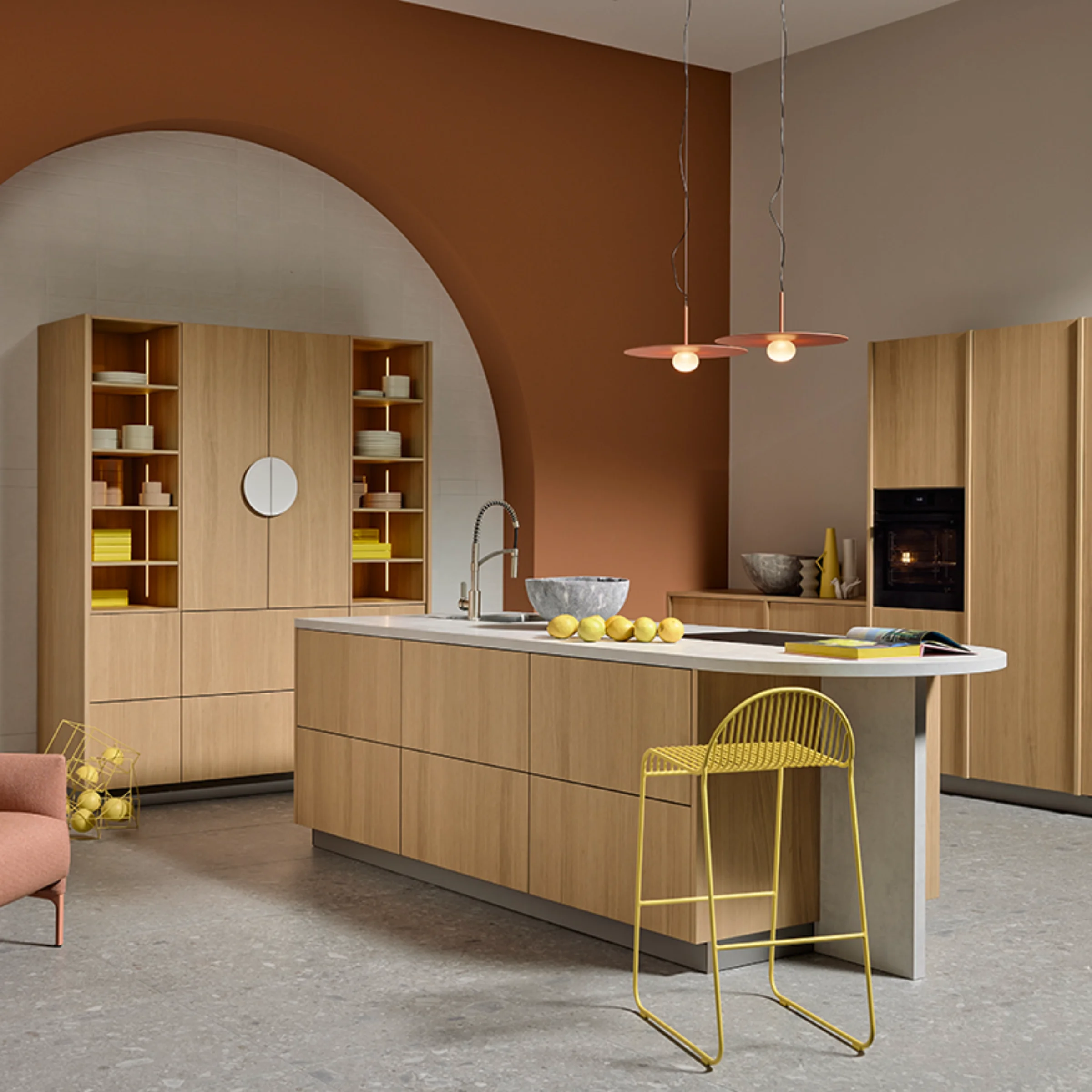 Offene Wohnküche in Eiche Bianco mit Kochinsel, hohen Schränken und harmonischem Farbspiel aus Terrakotta, Gelb und Naturholz. Stylische Beleuchtung und zeitloses Design von nolteneo.