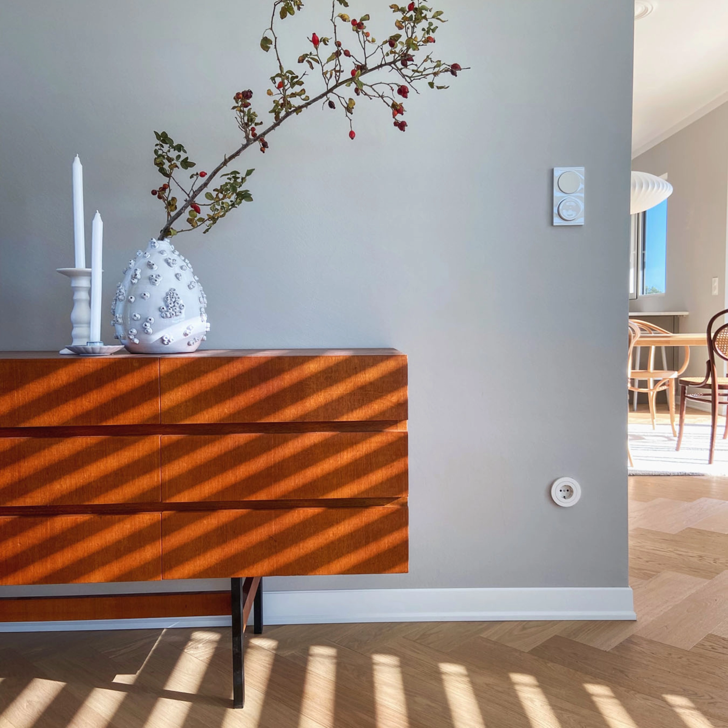Un buffet avec un vase et des bougies dans une pièce baignée de lumière, Nolte Living.