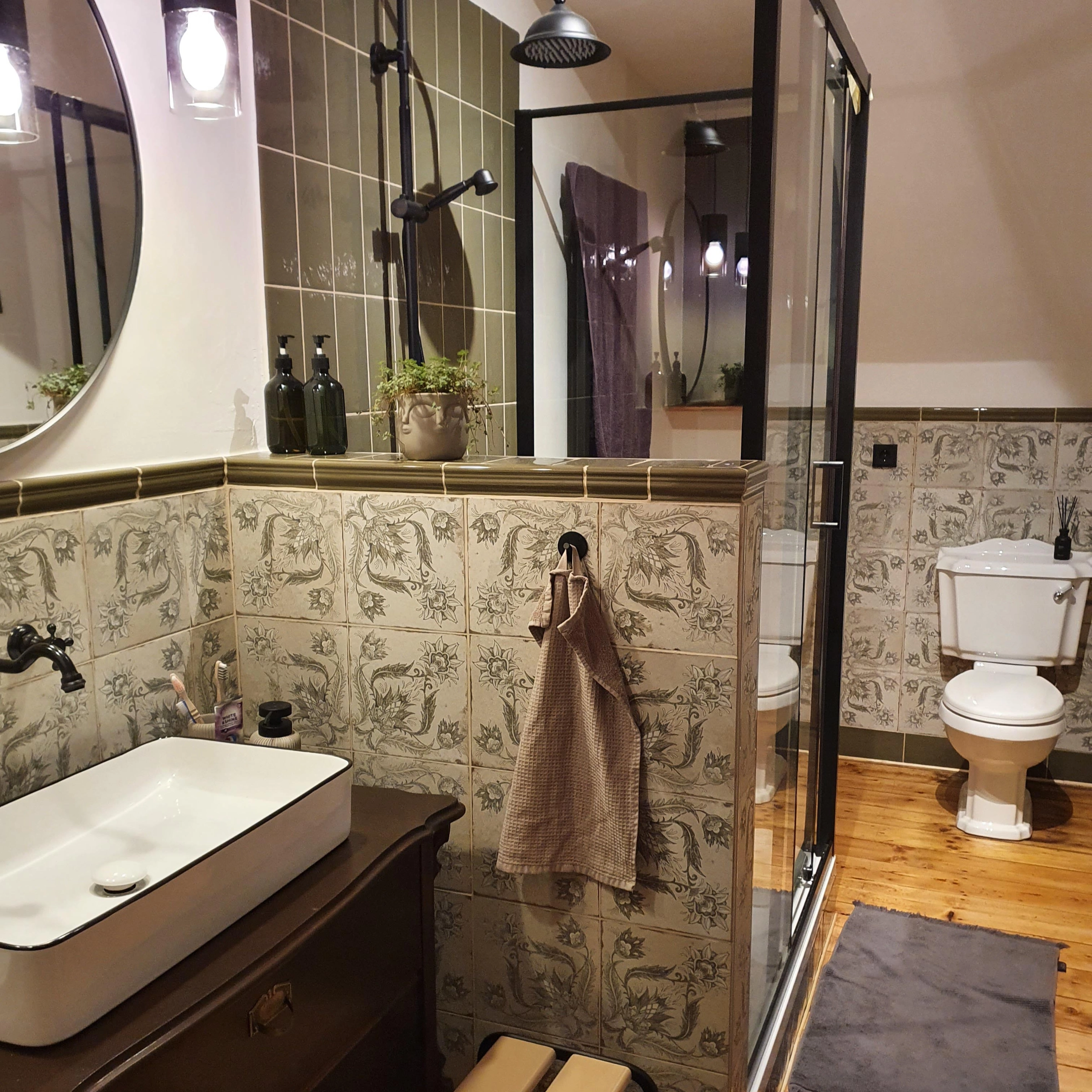 Salle de bain élégante avec douche, lavabo, plantes et motifs de carreaux. Nolte SPA.