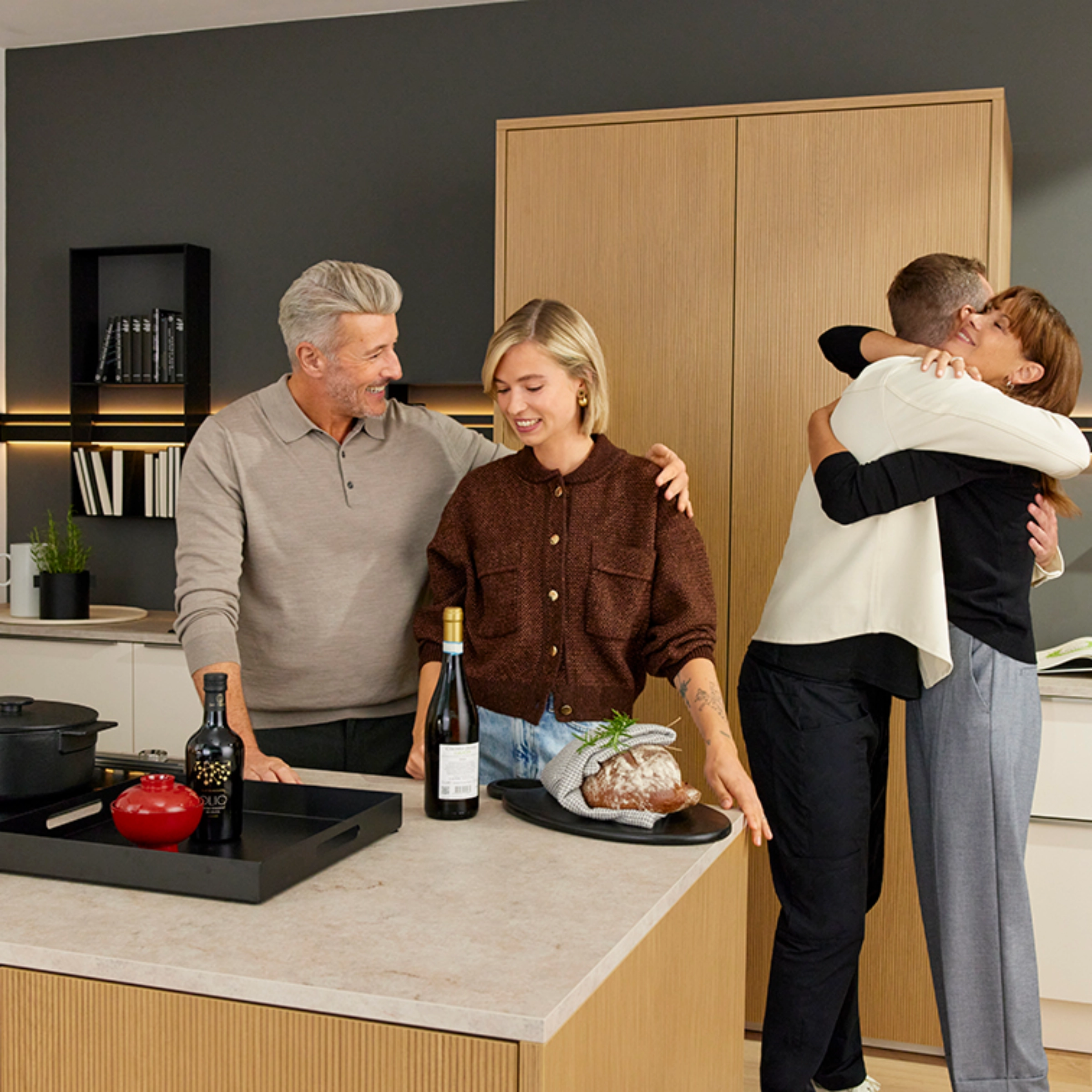 Dans une cuisine moderne de Nolte Kitchen, un groupe de personnes prépare ensemble un repas.