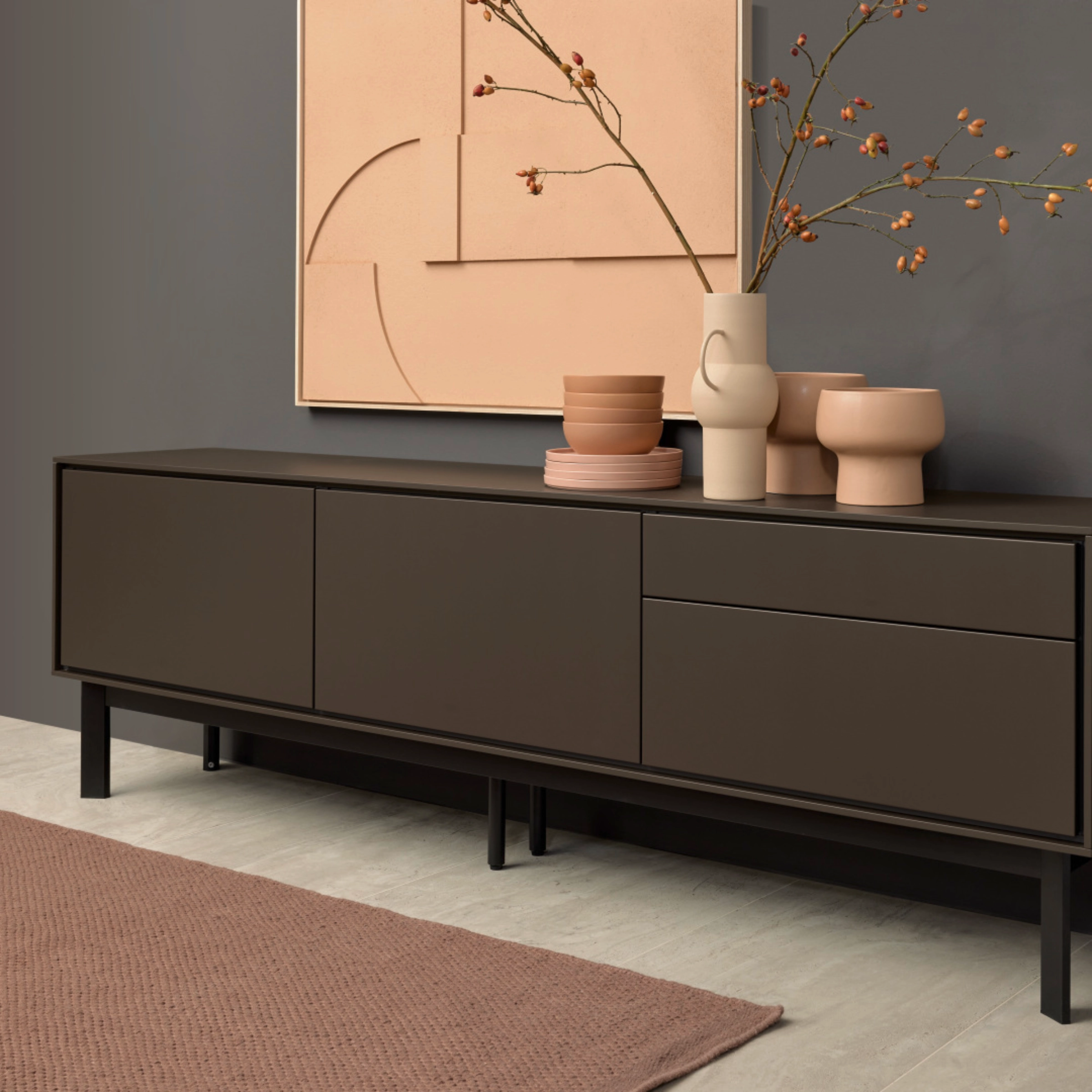 Een elegant dressoir met decoratie voor een grijze muur, deel van de Nolte Living collectie.