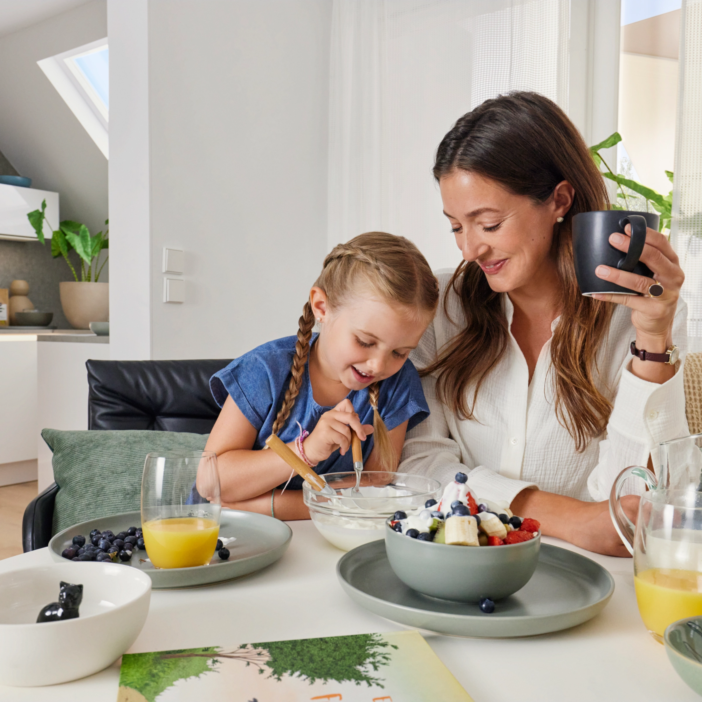 Une mère et sa fille prennent le petit-déjeuner ensemble dans une cuisine moderne de Nolte Kitchen.