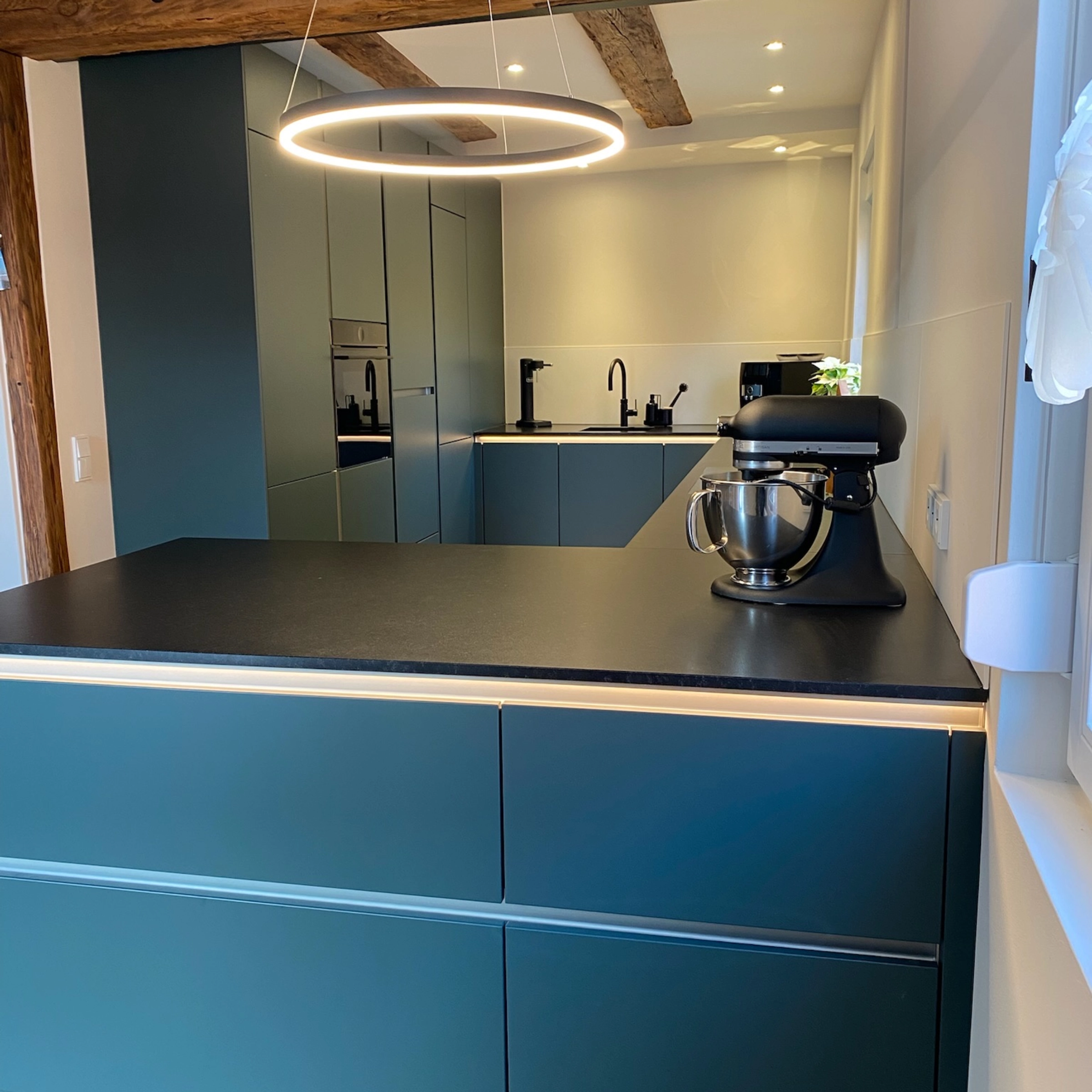 Cuisine moderne avec surfaces noires et poutres en bois, Nolte Kitchen.