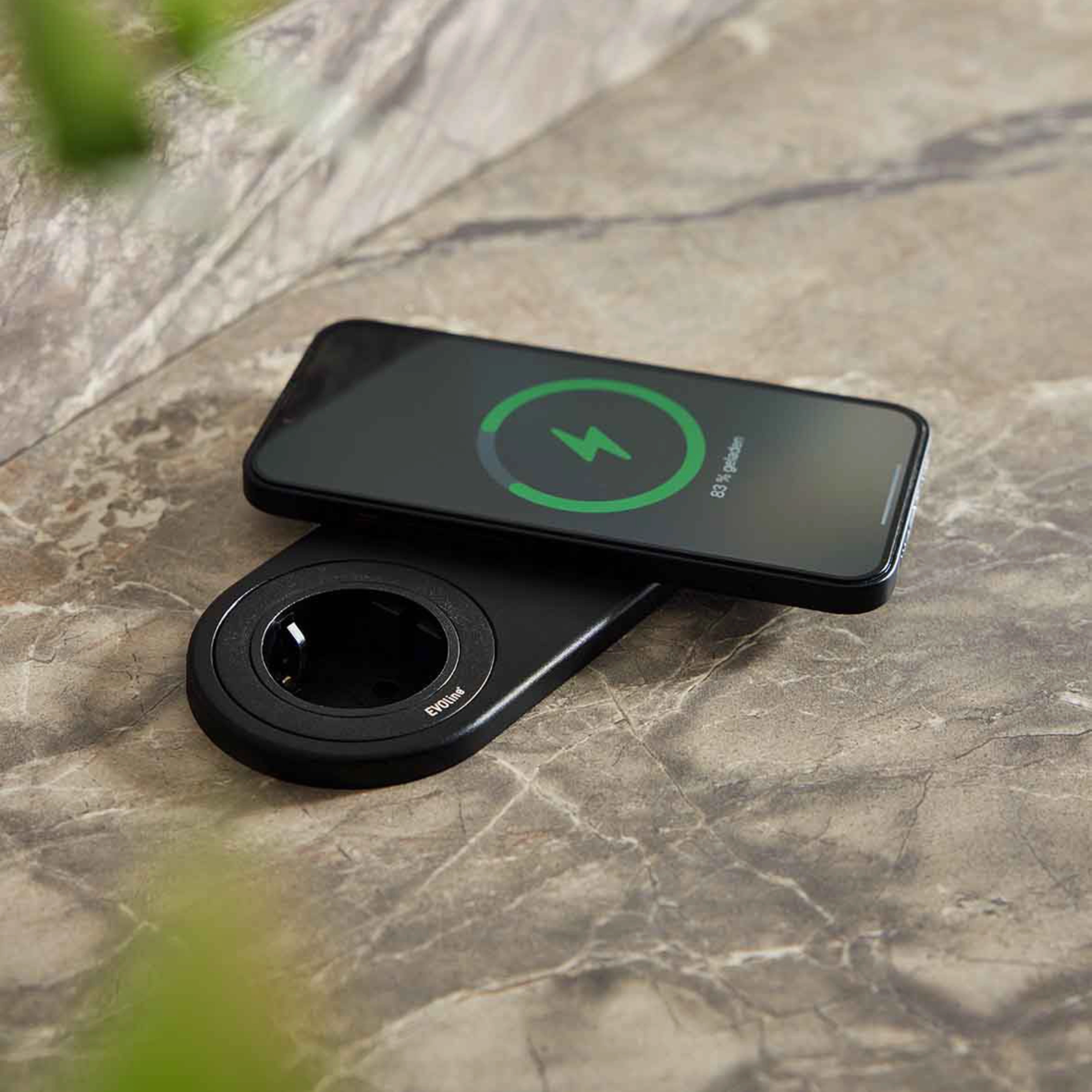 Un smartphone se recharge sans fil sur une plaque de marbre.