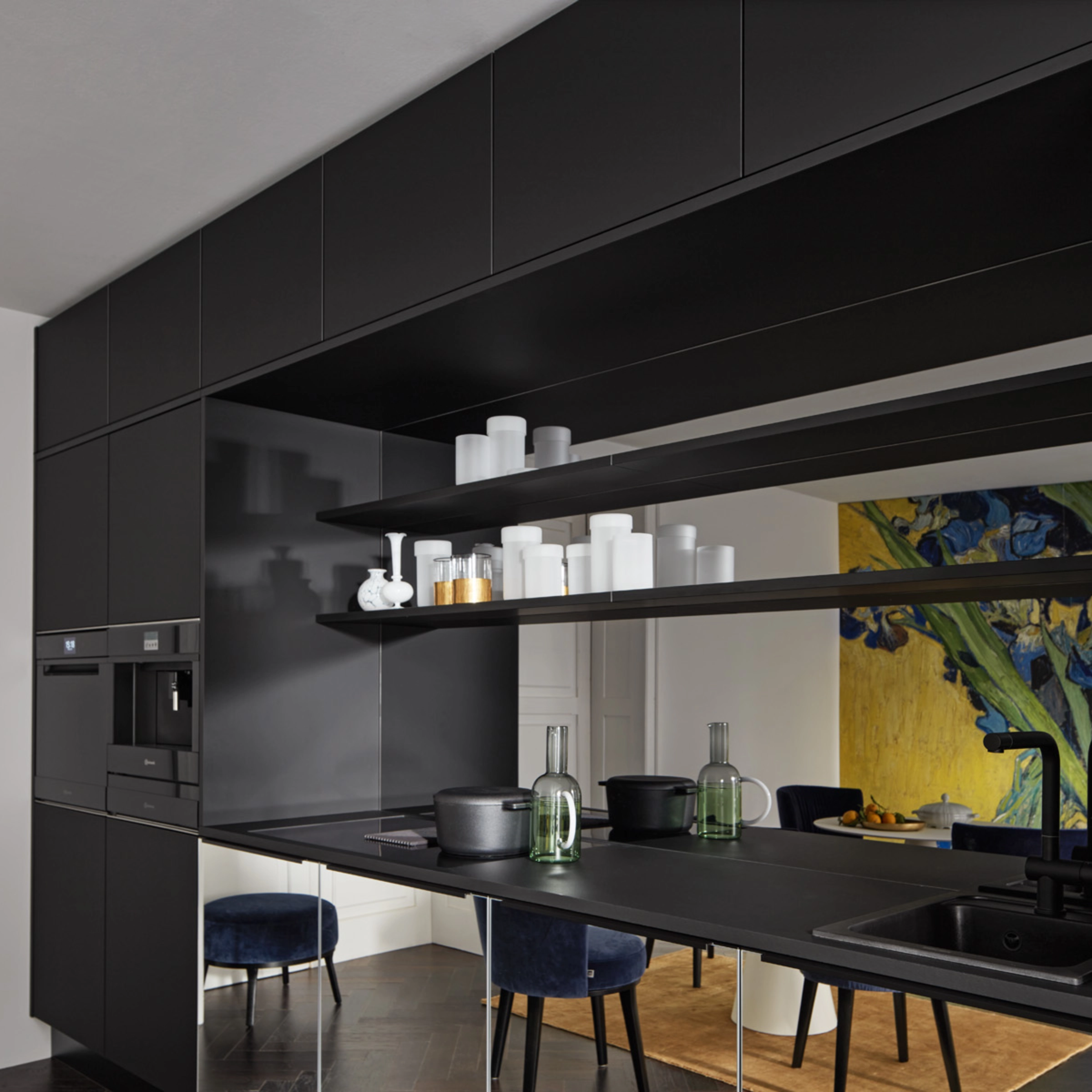 Eine moderne schwarze Küche mit Regalen und Geräten, gestaltet von Nolte Küchen.