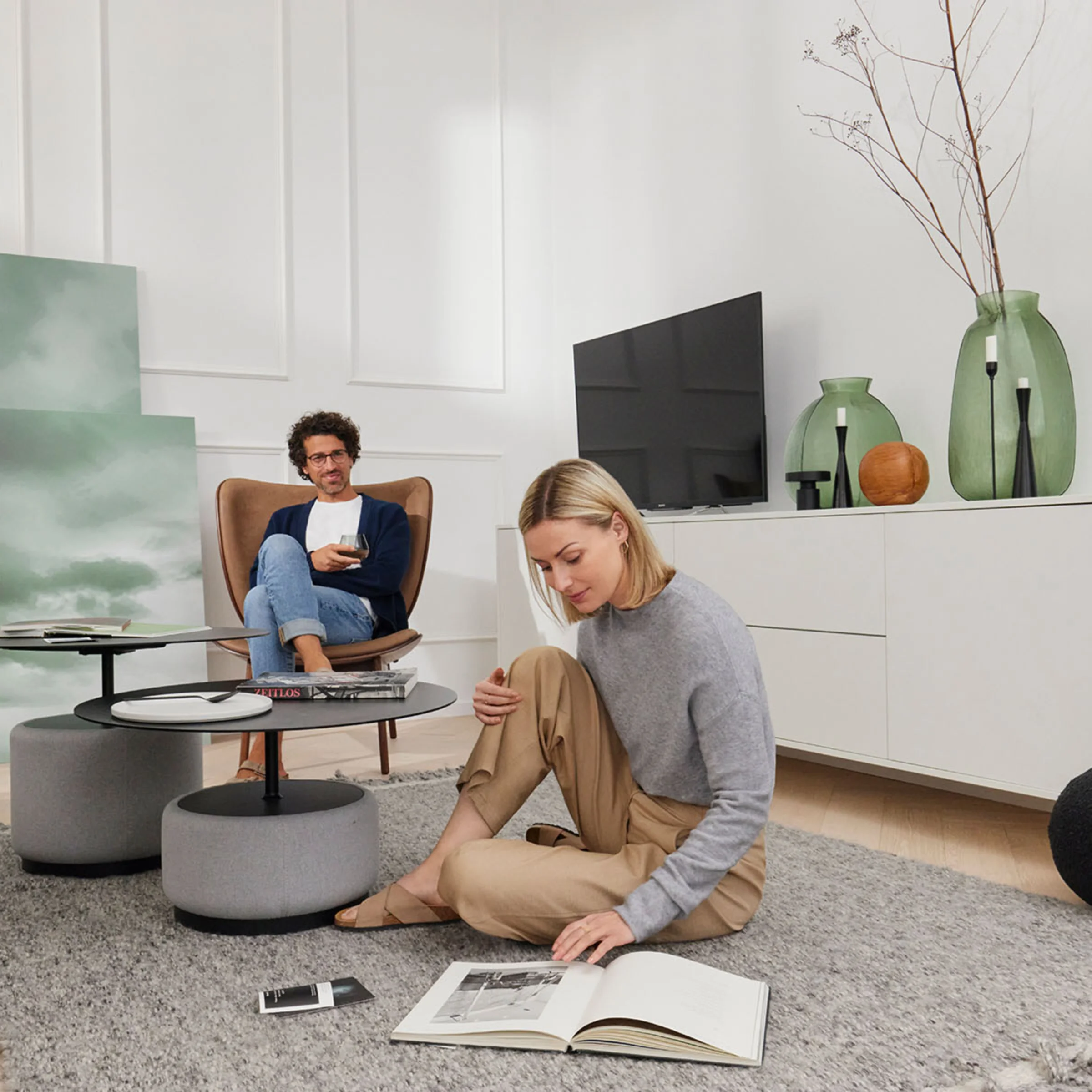 Ein Paar entspannt in einem stilvollen Wohnzimmer mit modernen Möbeln von Nolte Living.