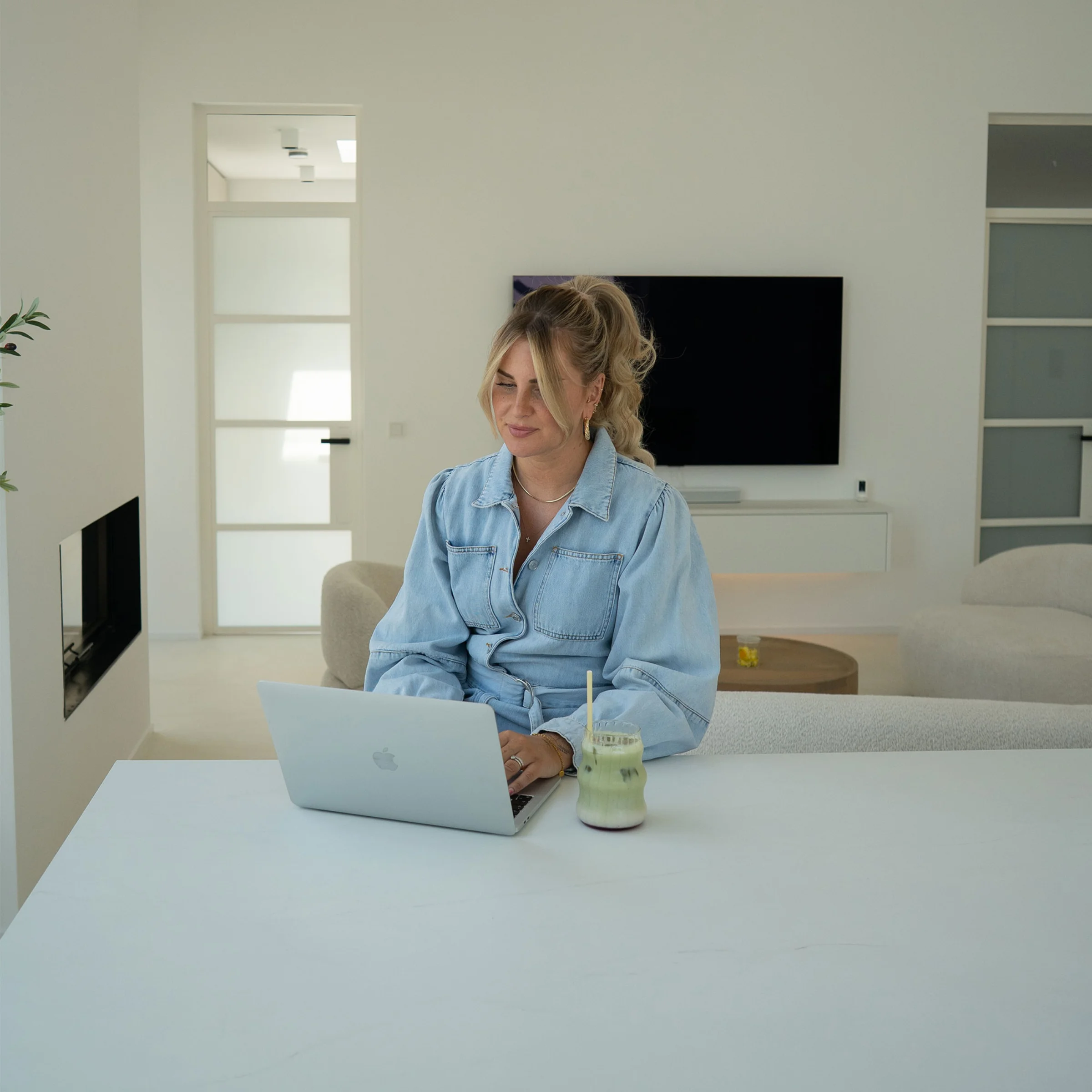 Une femme travaille sur un ordinateur portable dans un salon moderne. Nolte Living.