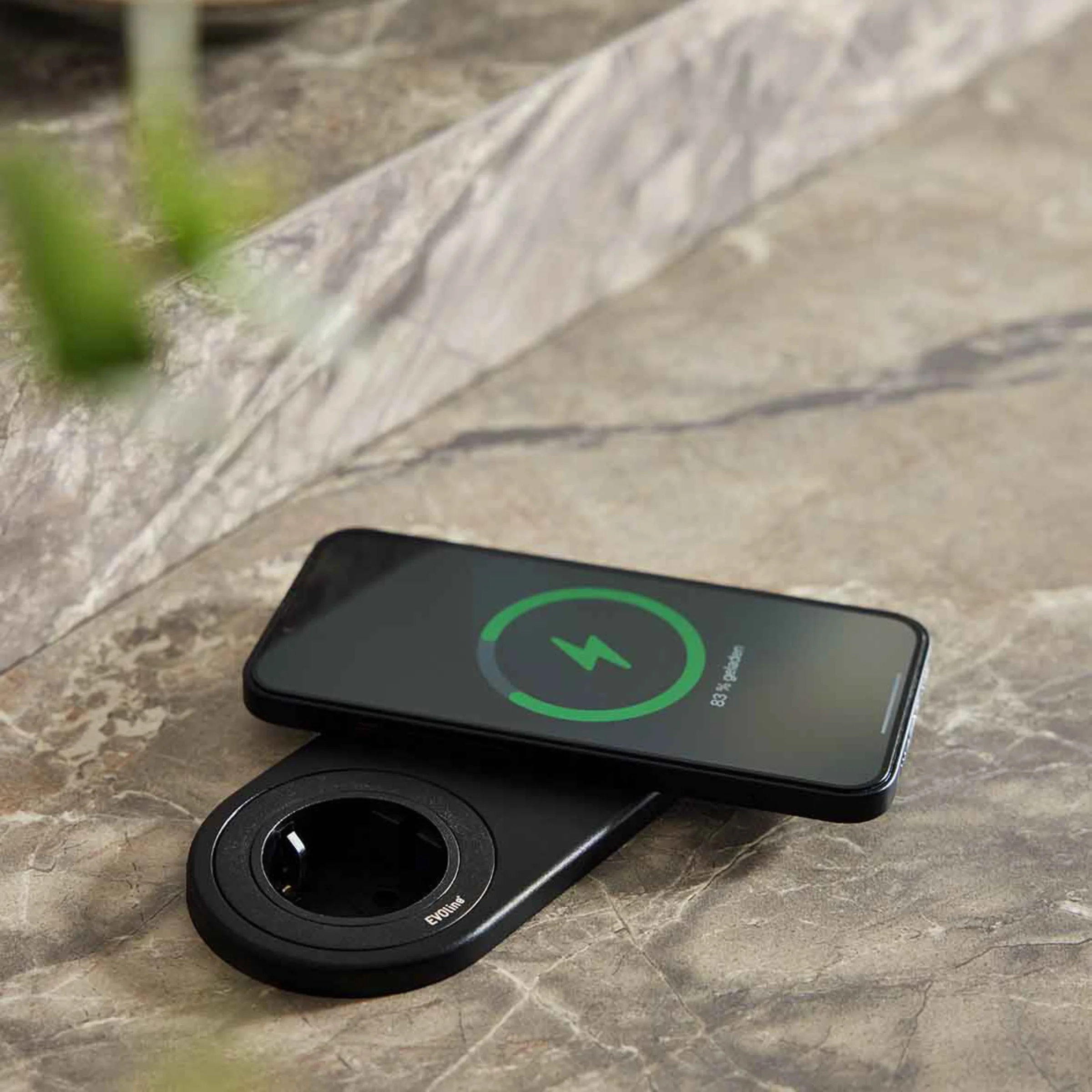 Un smartphone se recharge sans fil sur une surface en marbre appartenant à Nolte Kitchen.