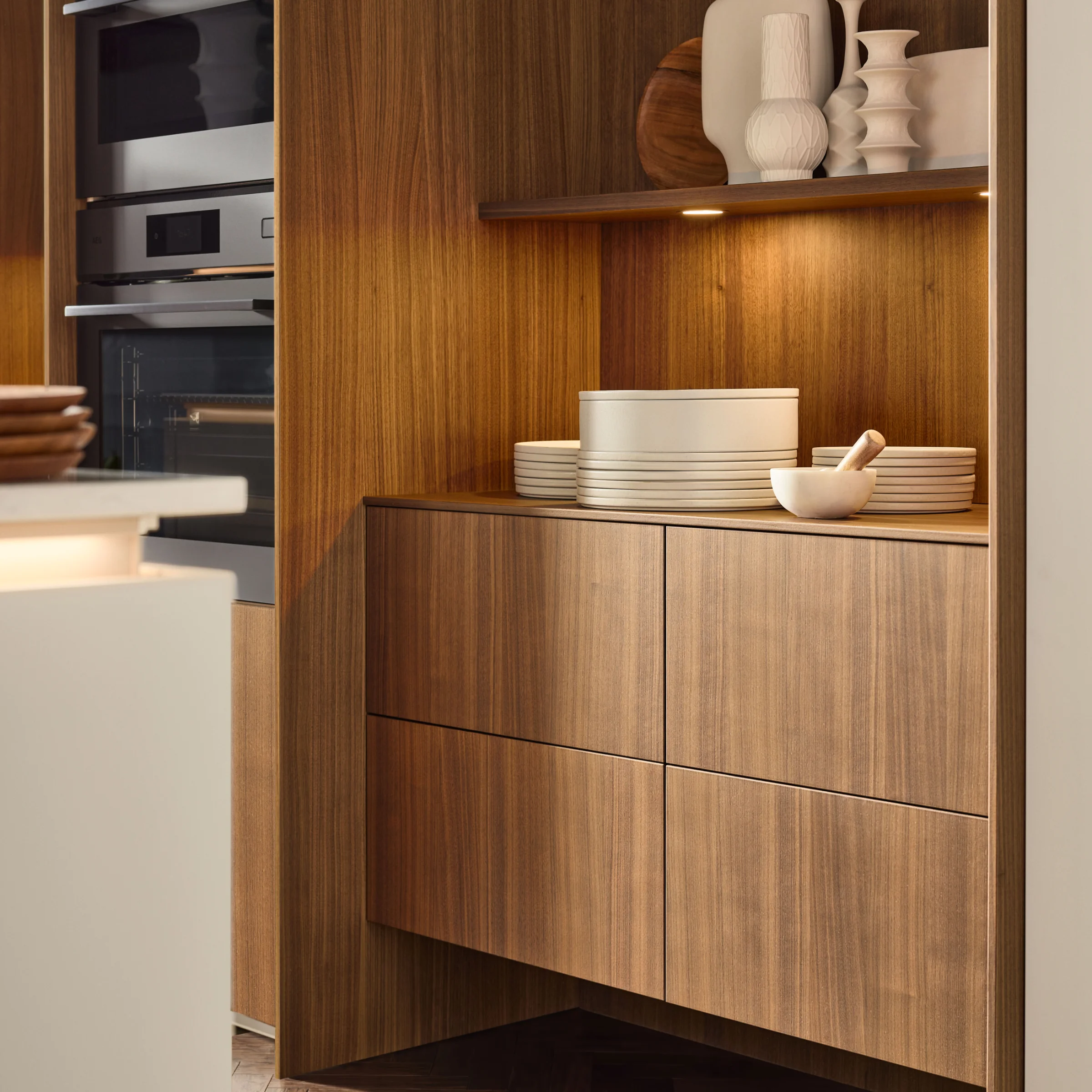 A modern kitchen with wooden cabinets and an integrated oven by Nolte Küchen.