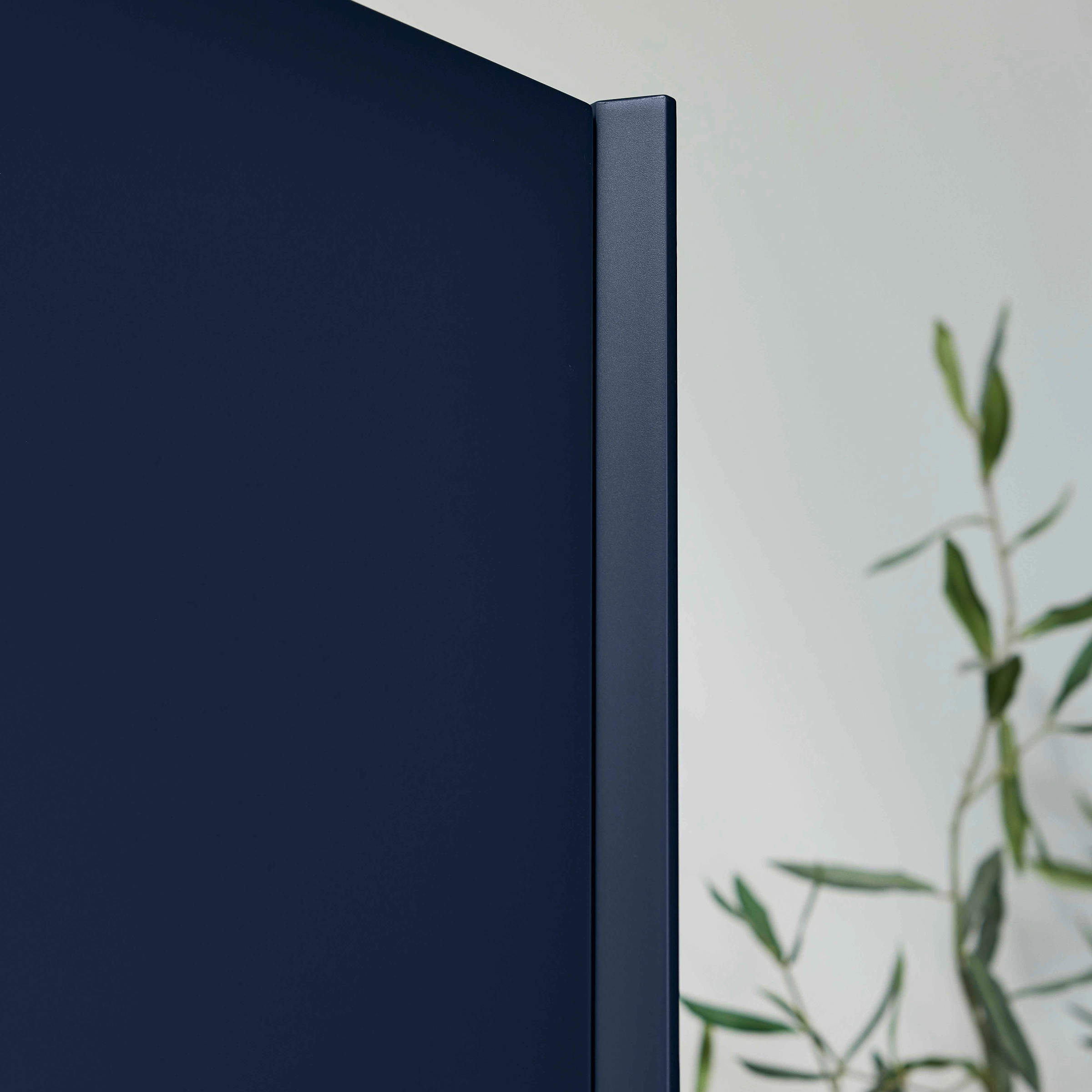 Eine blaue Schranktür mit einer Pflanze im Hintergrund, modernes Design von Nolte Küchen.