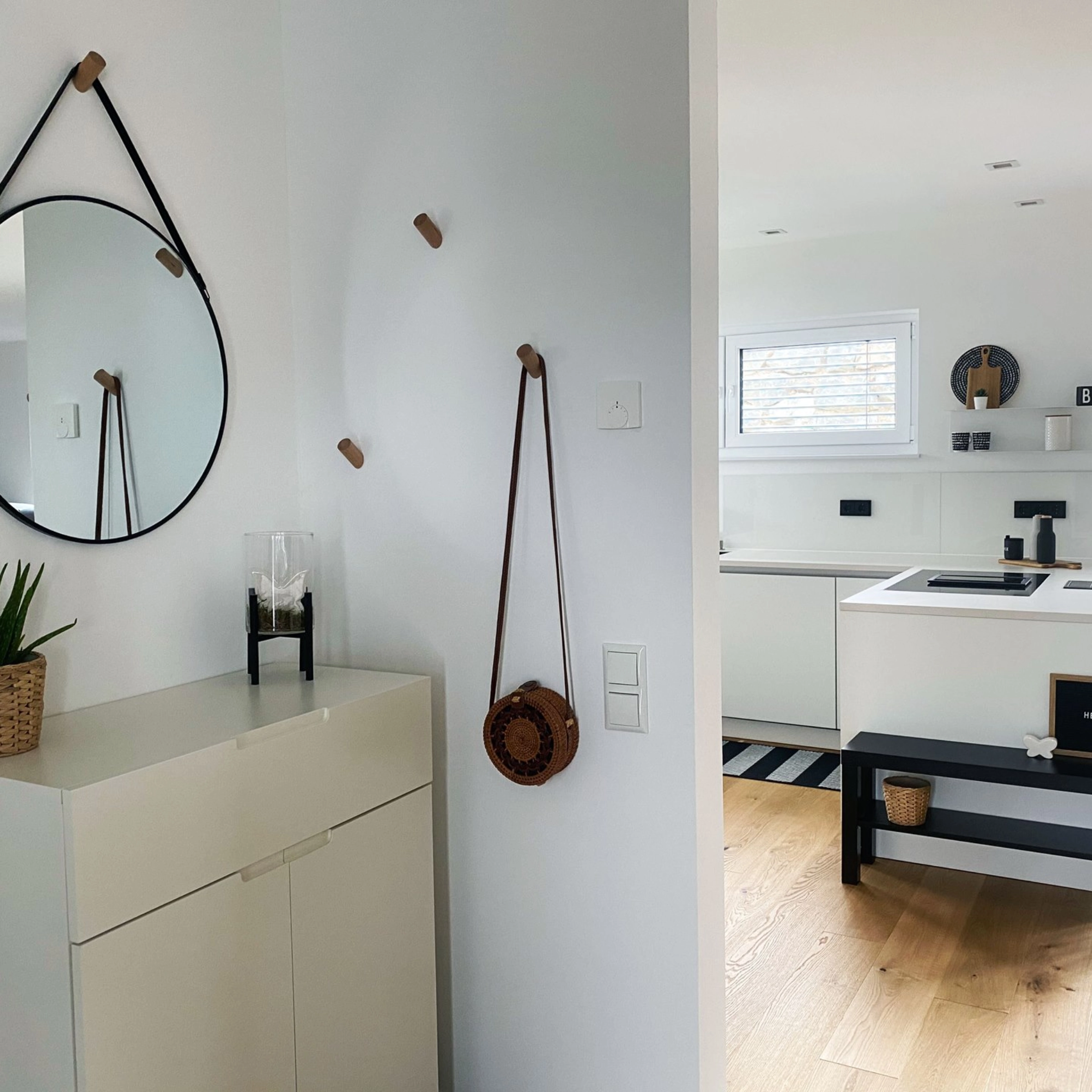 Une cuisine moderne avec des armoires blanches et des détails en bois, équipée par Nolte Kitchen.