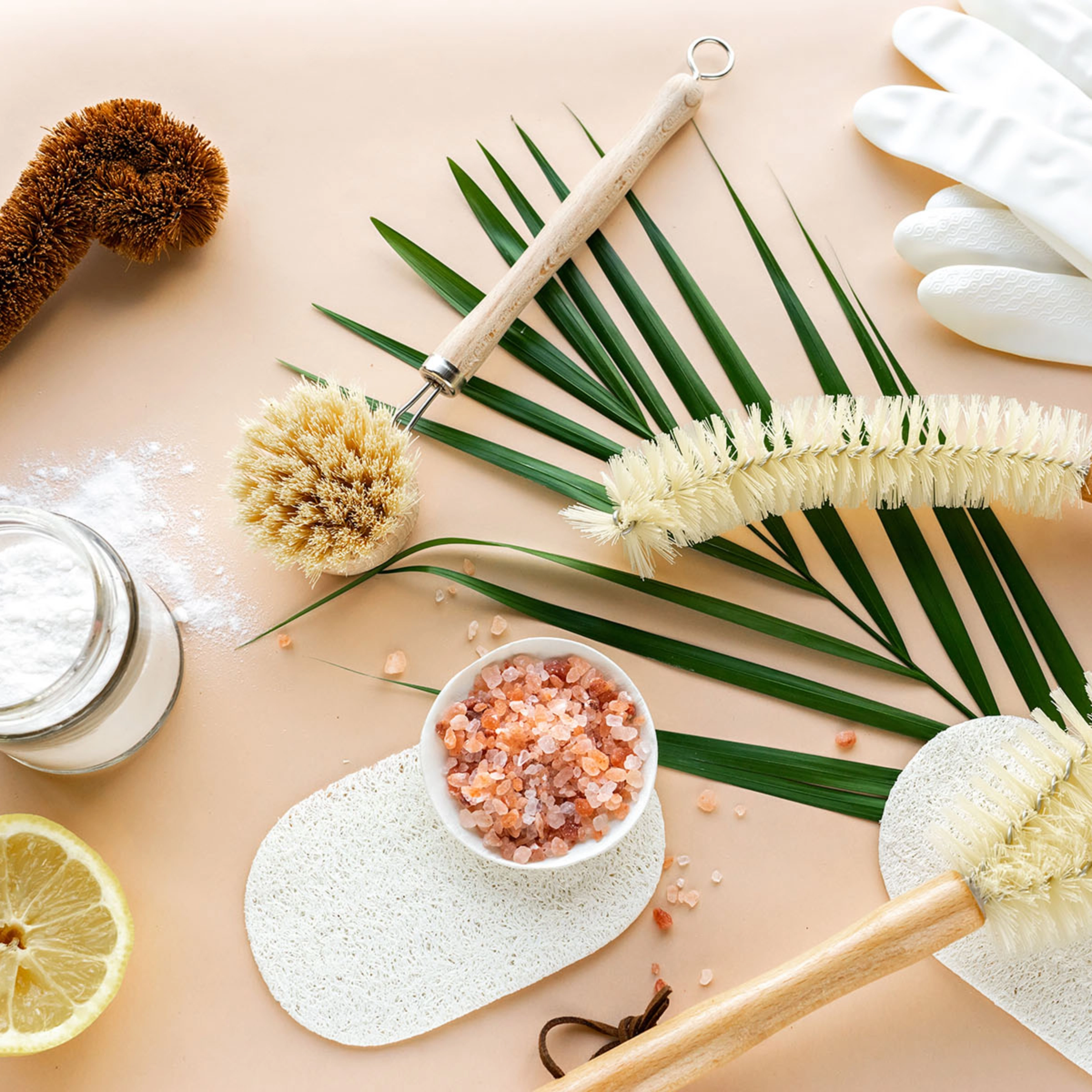 Ustensiles de nettoyage naturels, tranche de citron et sel sur fond clair.