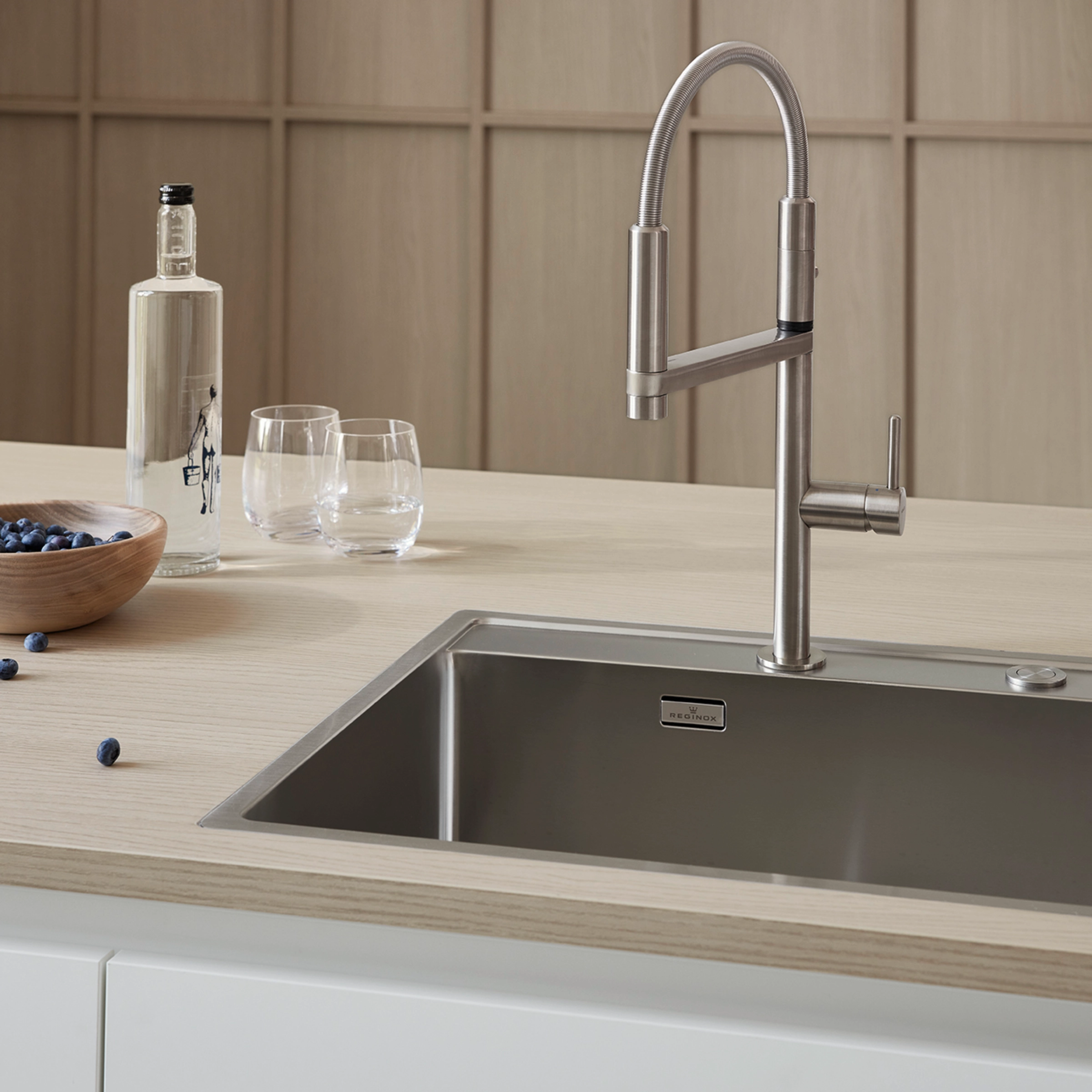 Cuisine moderne avec évier en acier inoxydable et plan de travail en bois, complétée par "Nolte Kitchen".