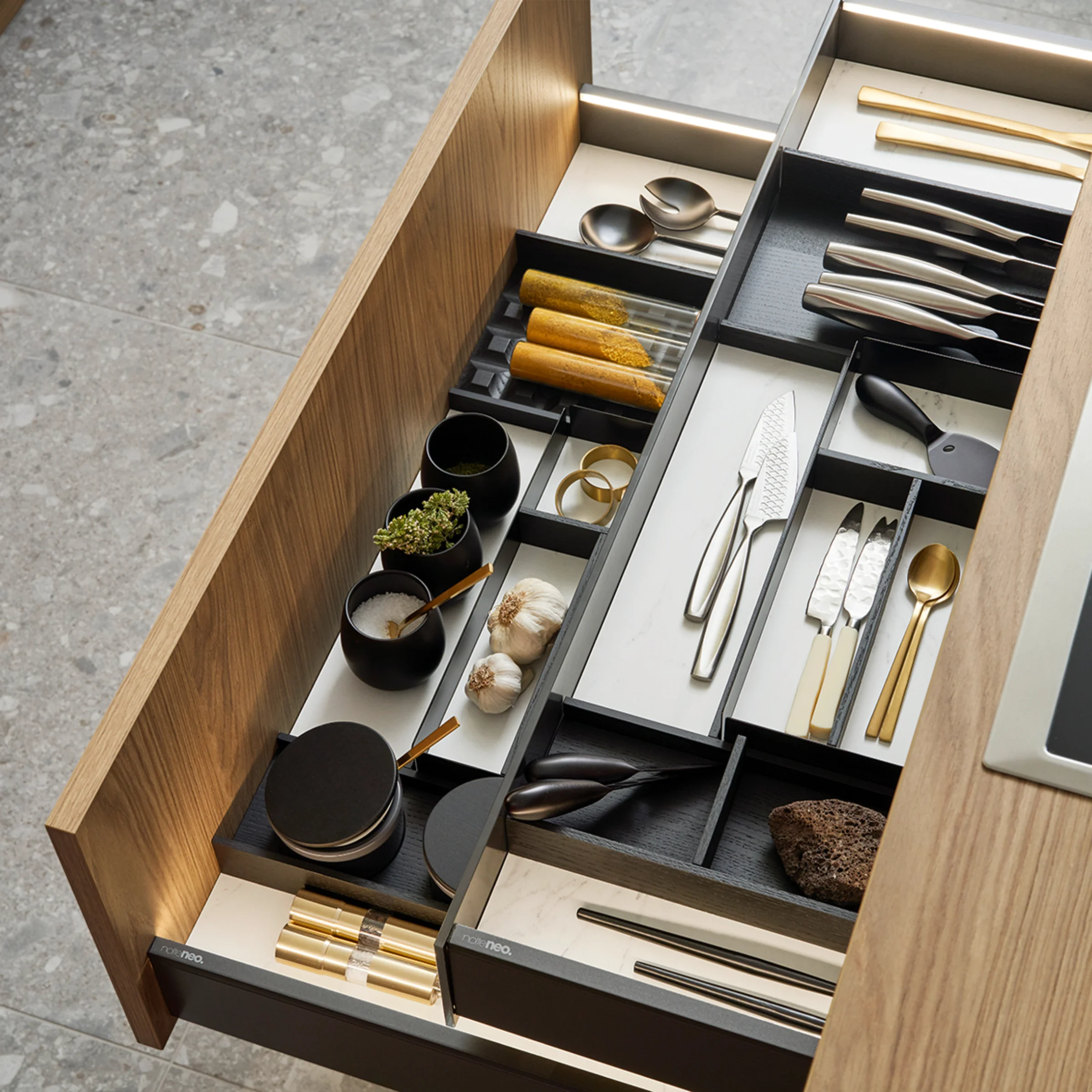 Een open keukenlade met bestek en keukengerei in een modern ontwerp van Nolte Keukens.