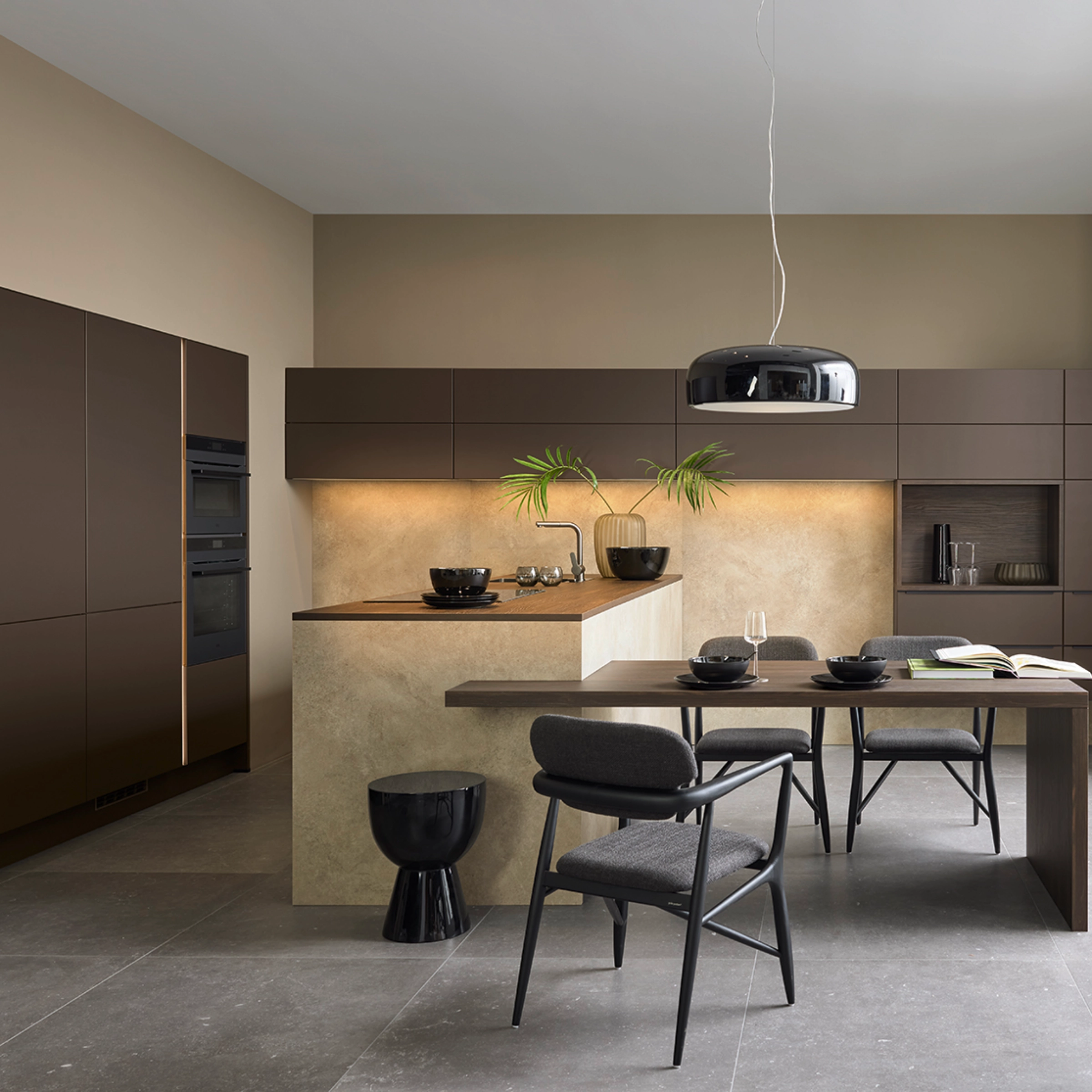 A modern kitchen with dark cabinets and an island; Nolte kitchen design.