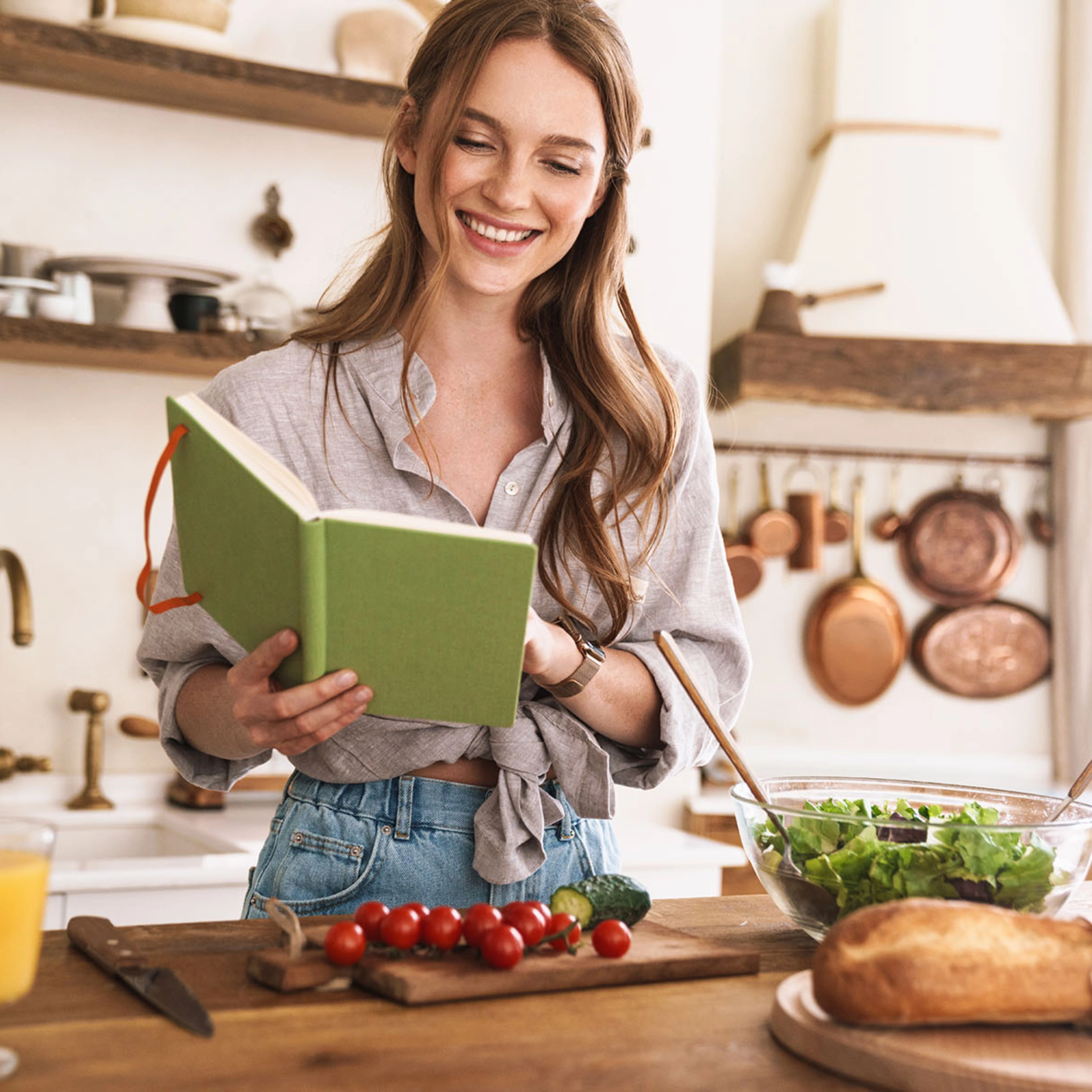 Une femme cuisine dans une cuisine avec des ingrédients frais, Nolte Kitchen.