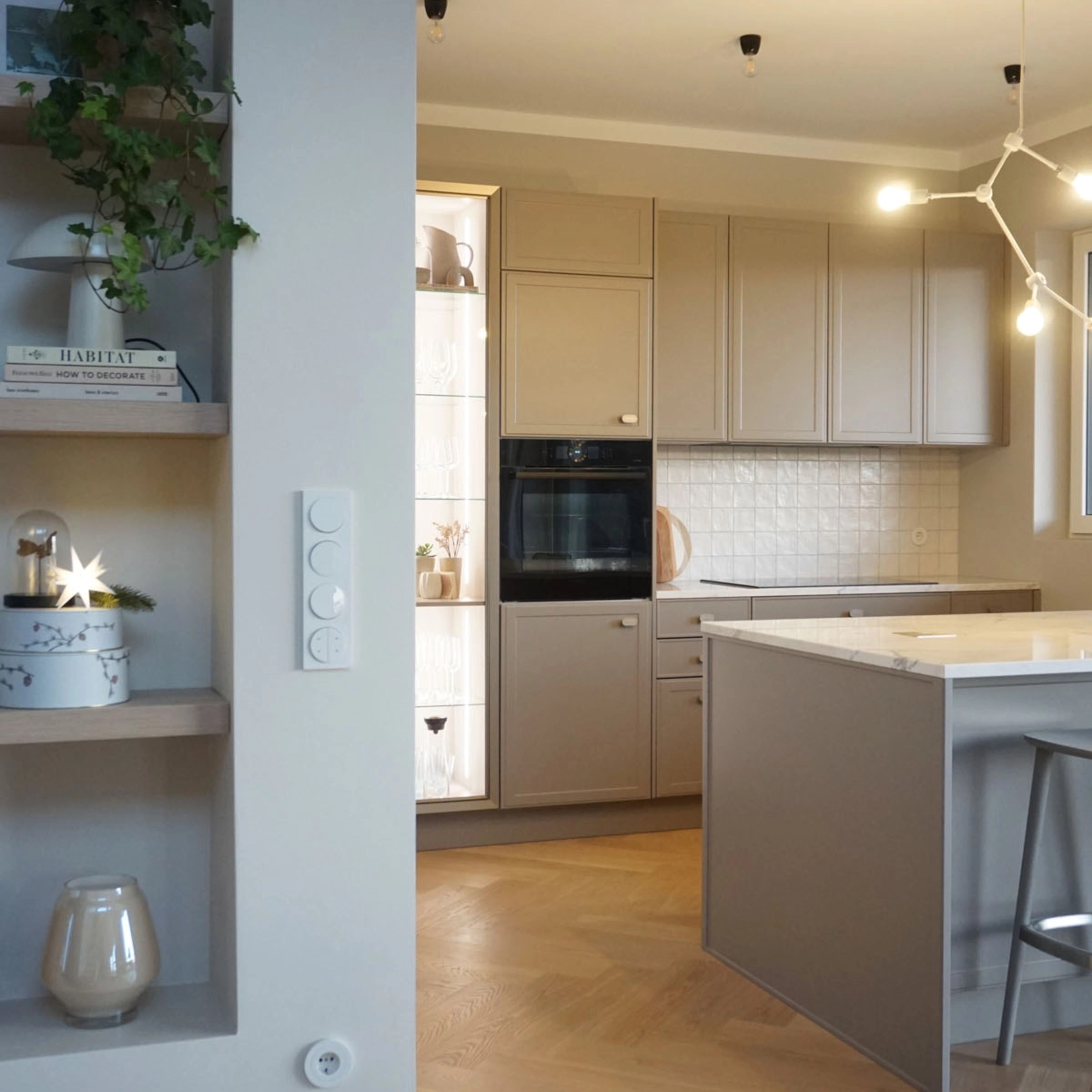 Cuisine moderne avec îlot et armoires claires, design Nolte Kitchen.