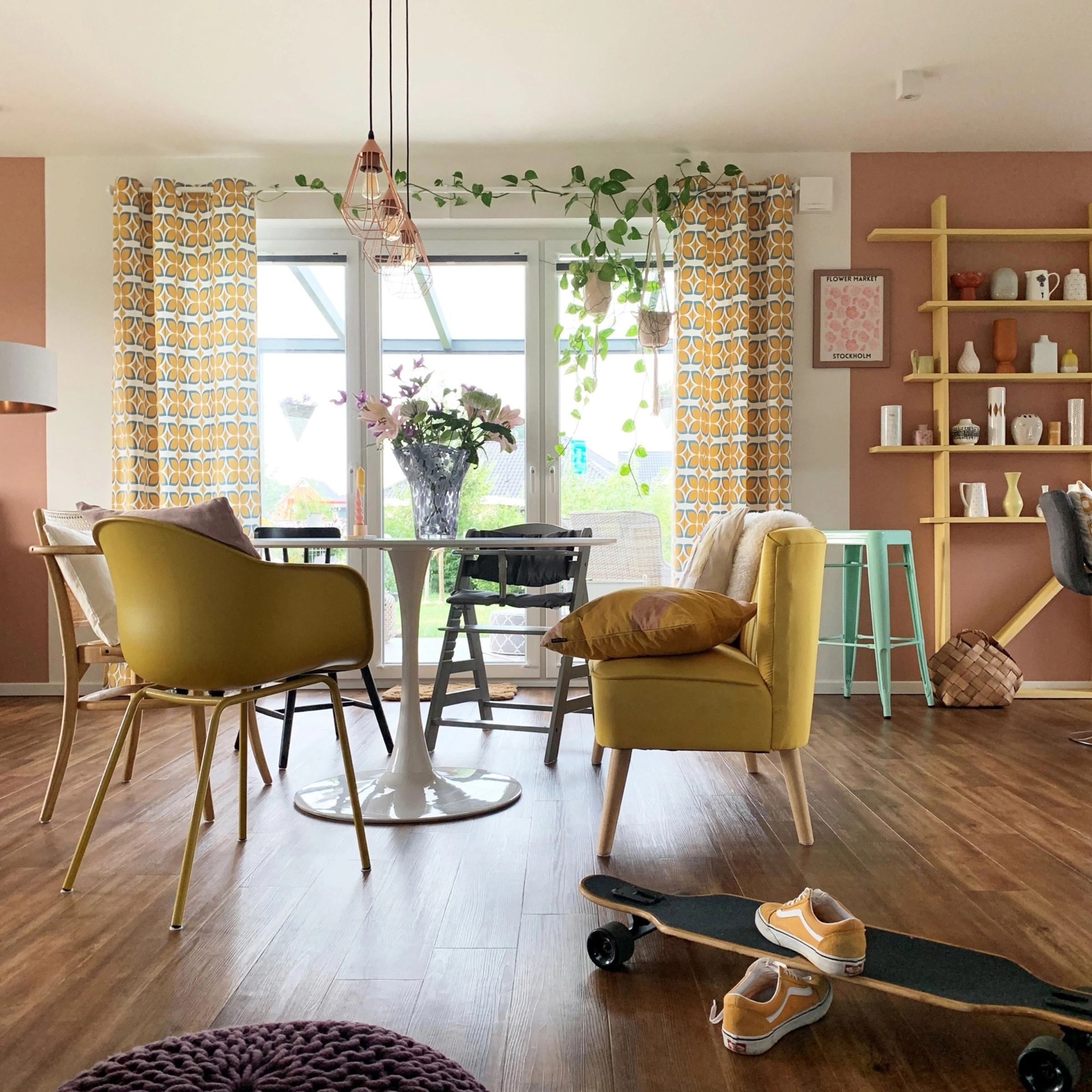 A modern living room with a yellow chair and skateboard on wooden floor, designed by Nolte Living.