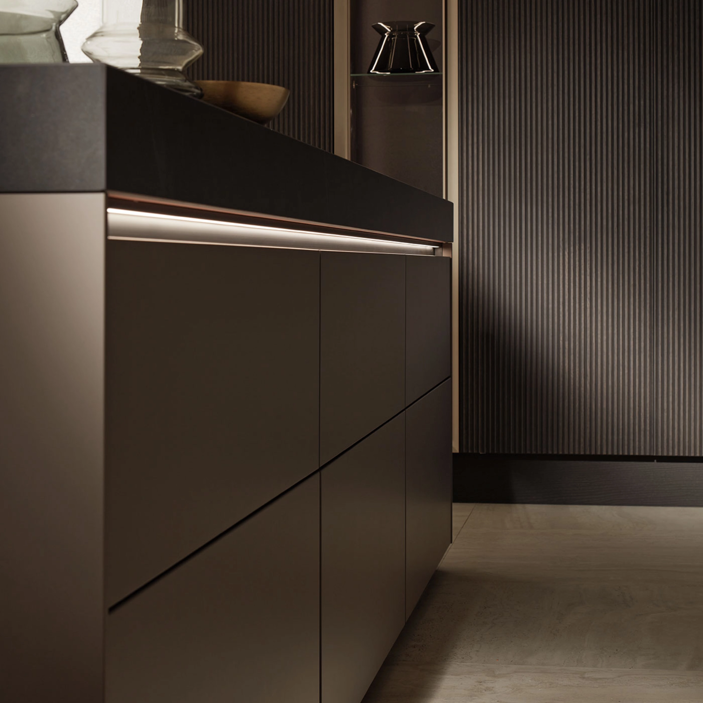 Cuisine moderne avec armoires sombres élégantes et éclairage de Nolte Kitchen.