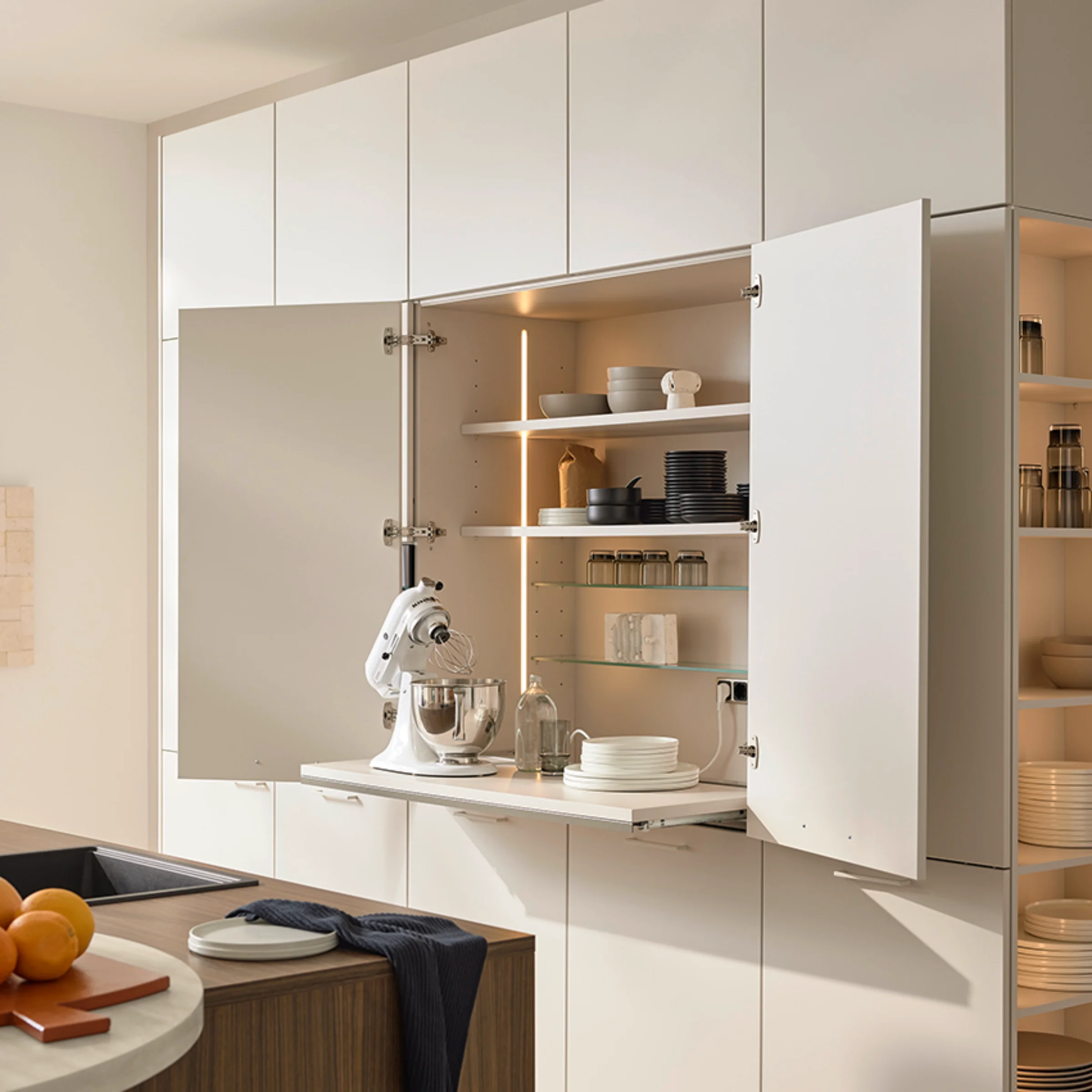 Modern kitchen with open cabinets displaying dishes. Nolte Küchen.