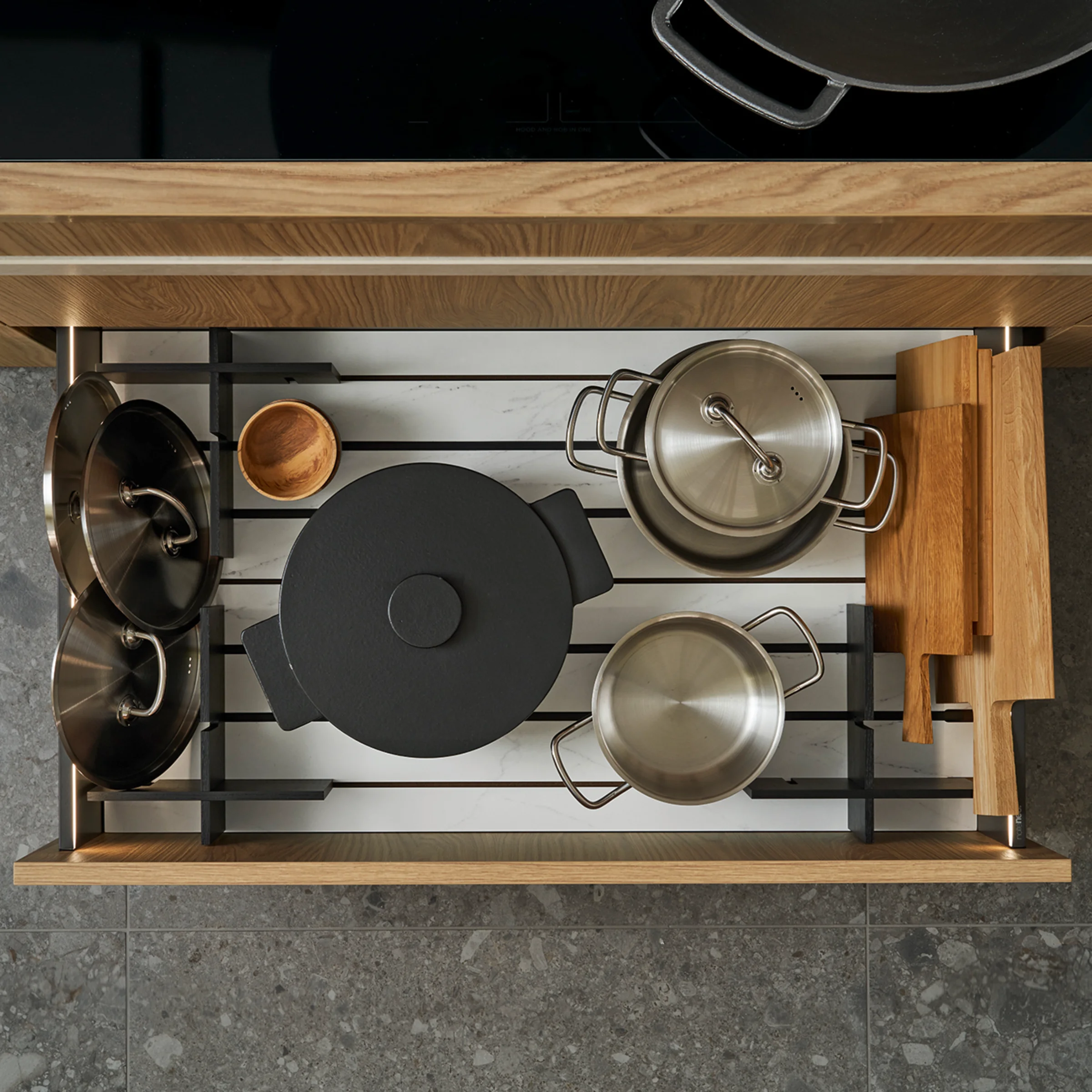 Un tiroir de cuisine ouvert avec des casseroles et poêles, partie de Nolte Kitchen.