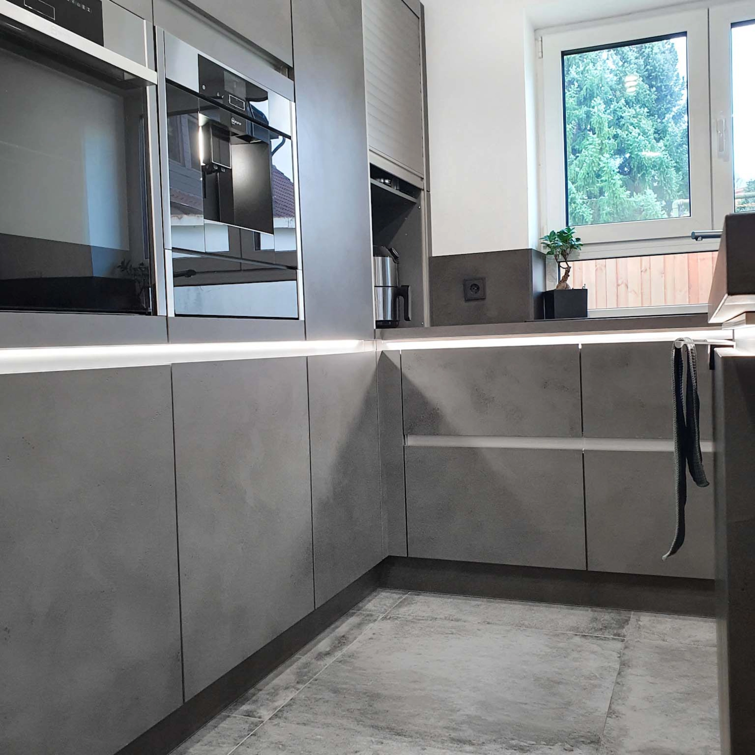 Une cuisine moderne avec des armoires grises et appareils, Nolte Kitchen.