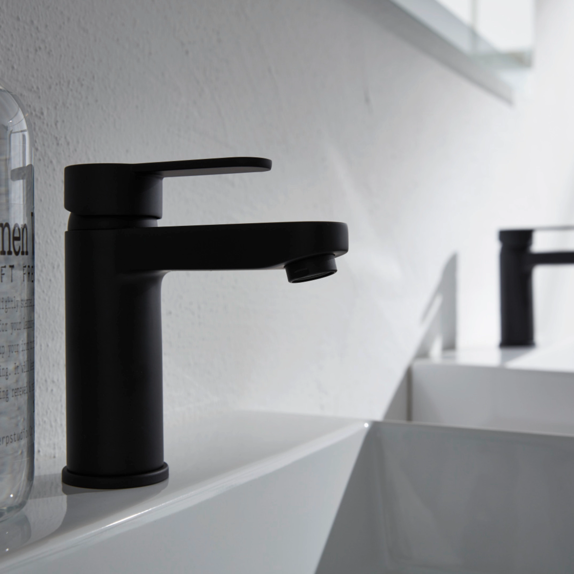 Een moderne badkamer met twee wastafels en zwarte kranen, Nolte SPA.
