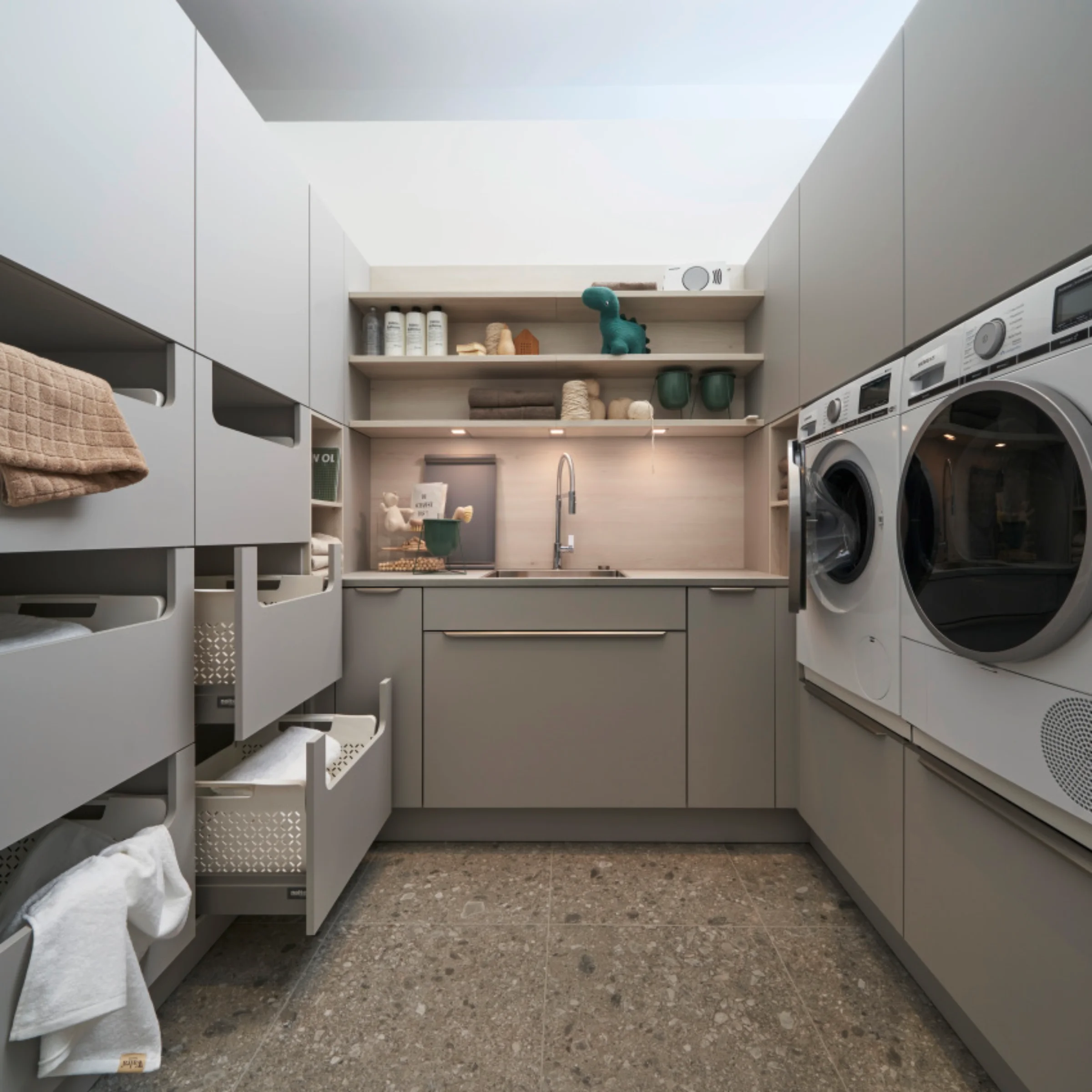 Ein moderner Hauswirtschaftsraum mit Waschmaschine und Trockner, gestaltet von Nolte Hauswirtschaftsräume.