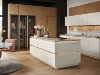 Une cuisine moderne avec îlot et détails en bois, décorée de fleurs. Nolte Kitchen.